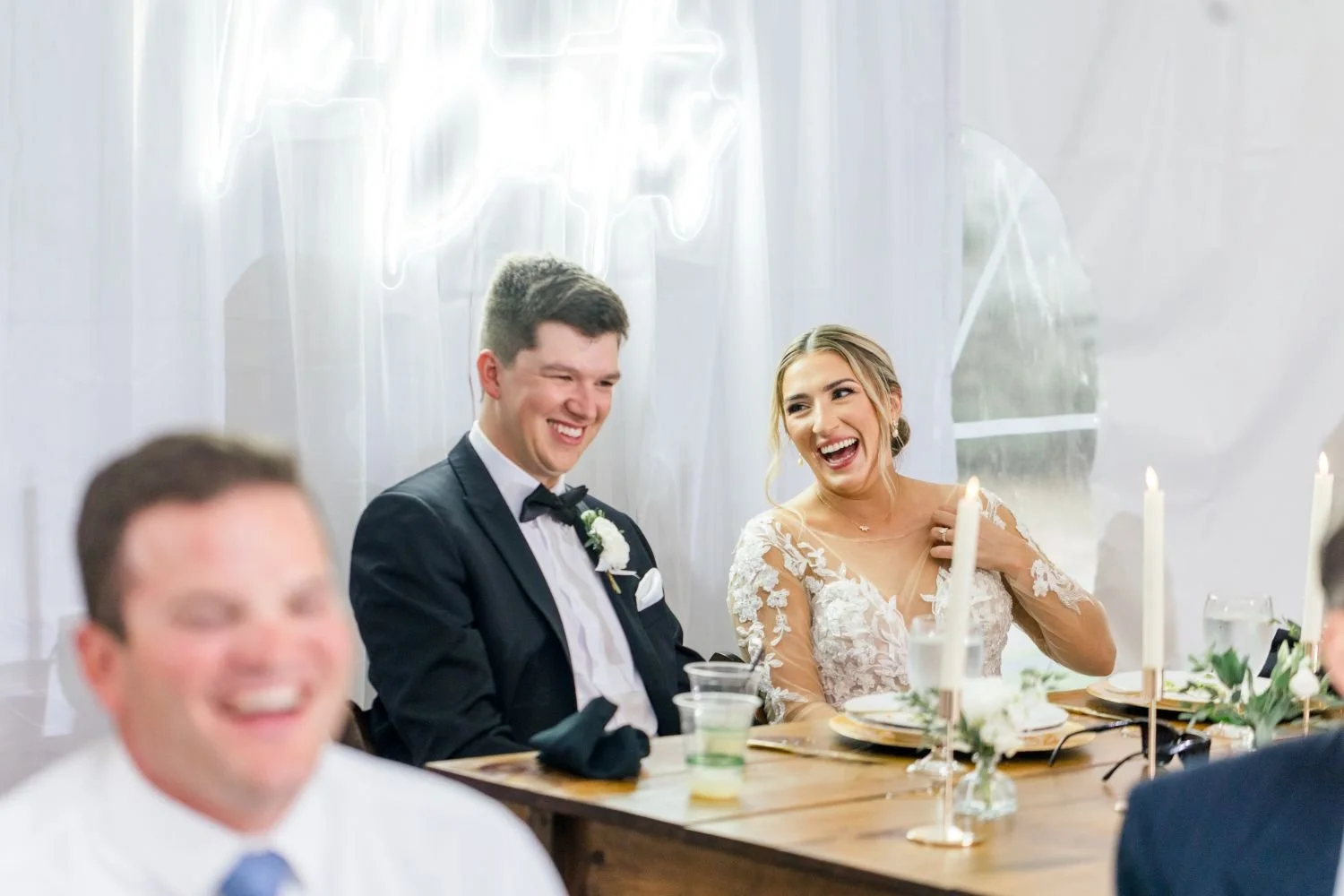 A bride and groom enjoy a laugh during the reception speeches at Historic Jasmine, a New Kent, Virginia wedding venue.