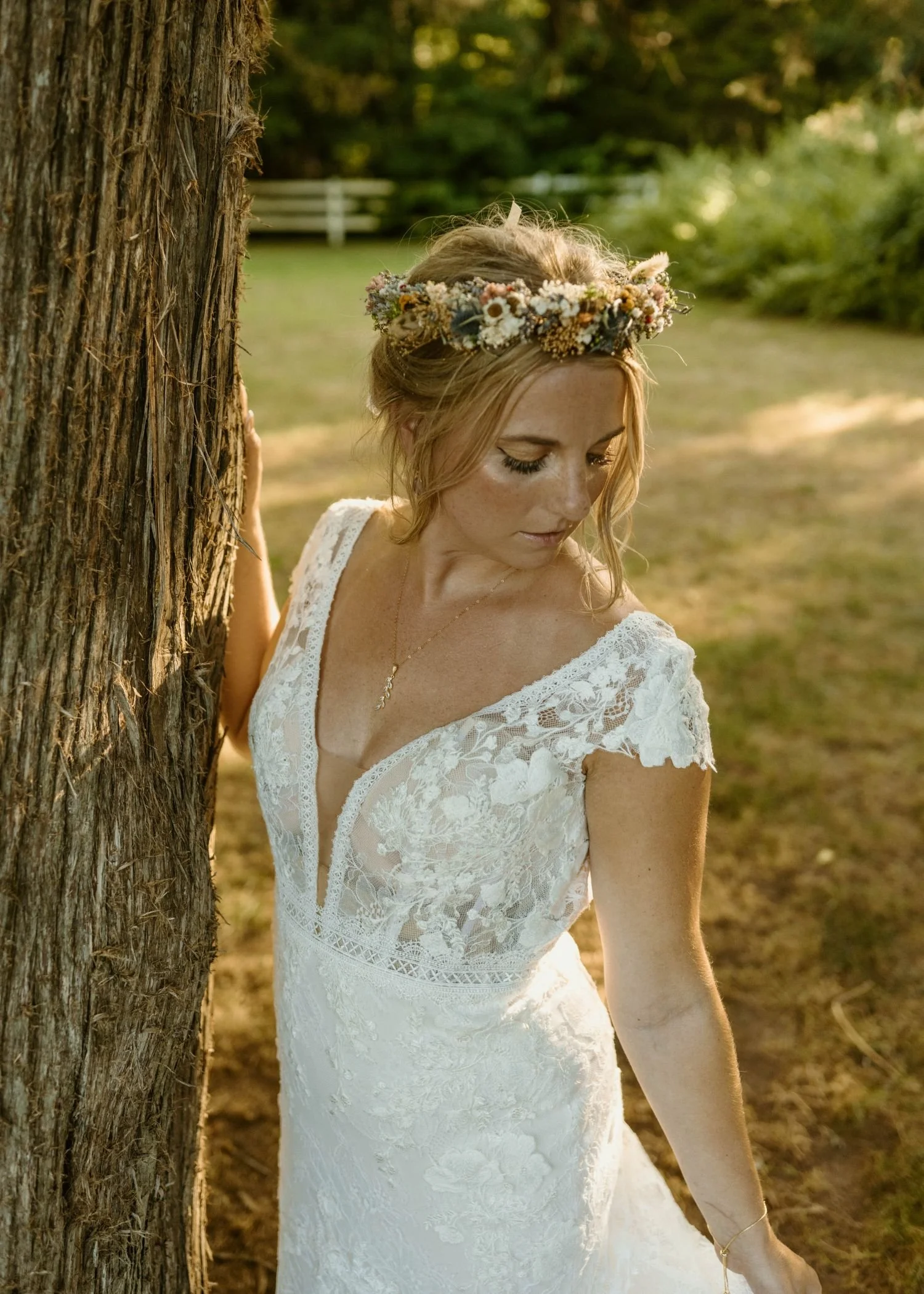 Bride poses next to a cedar tree located at Historic Jasmine, a fairytale wedding venue in New Kent, Virginia.