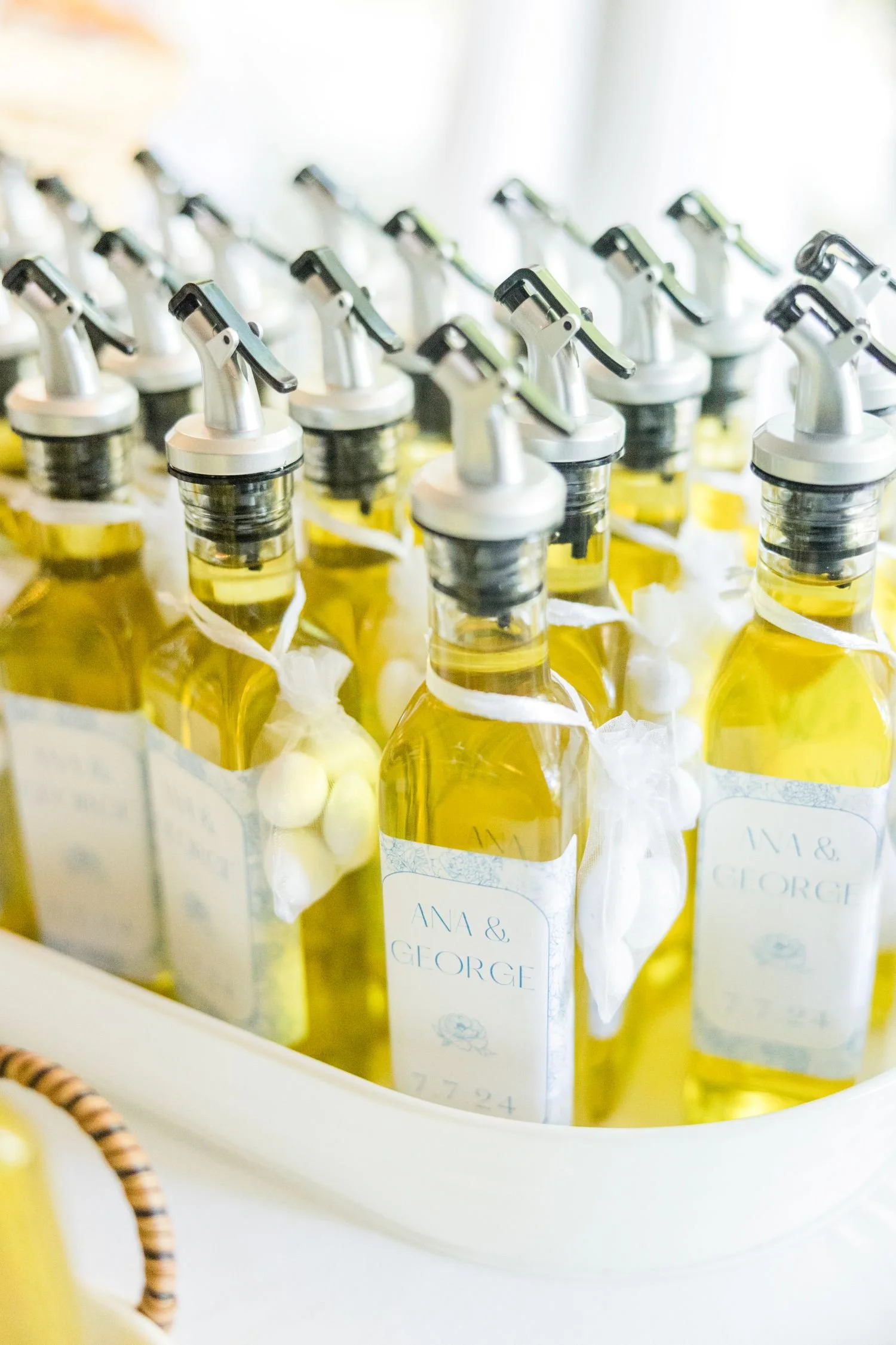 A display of personalized oil olive bottles given as wedding favors at a summer wedding hosted at Historic Jasmine, near Richmond, VA.