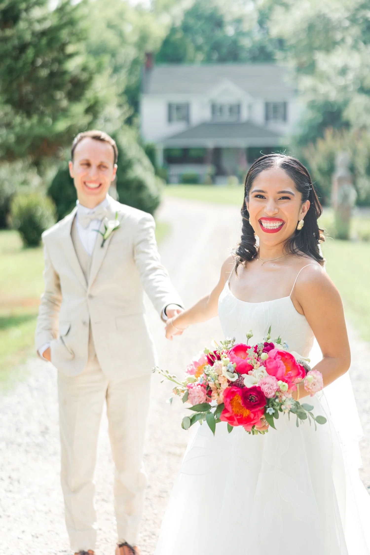 A bride and groom enjoy a stroll down the main gravel lane at Historic Jasmine, a whimsical wedding venue located near Richmond, Virginia.