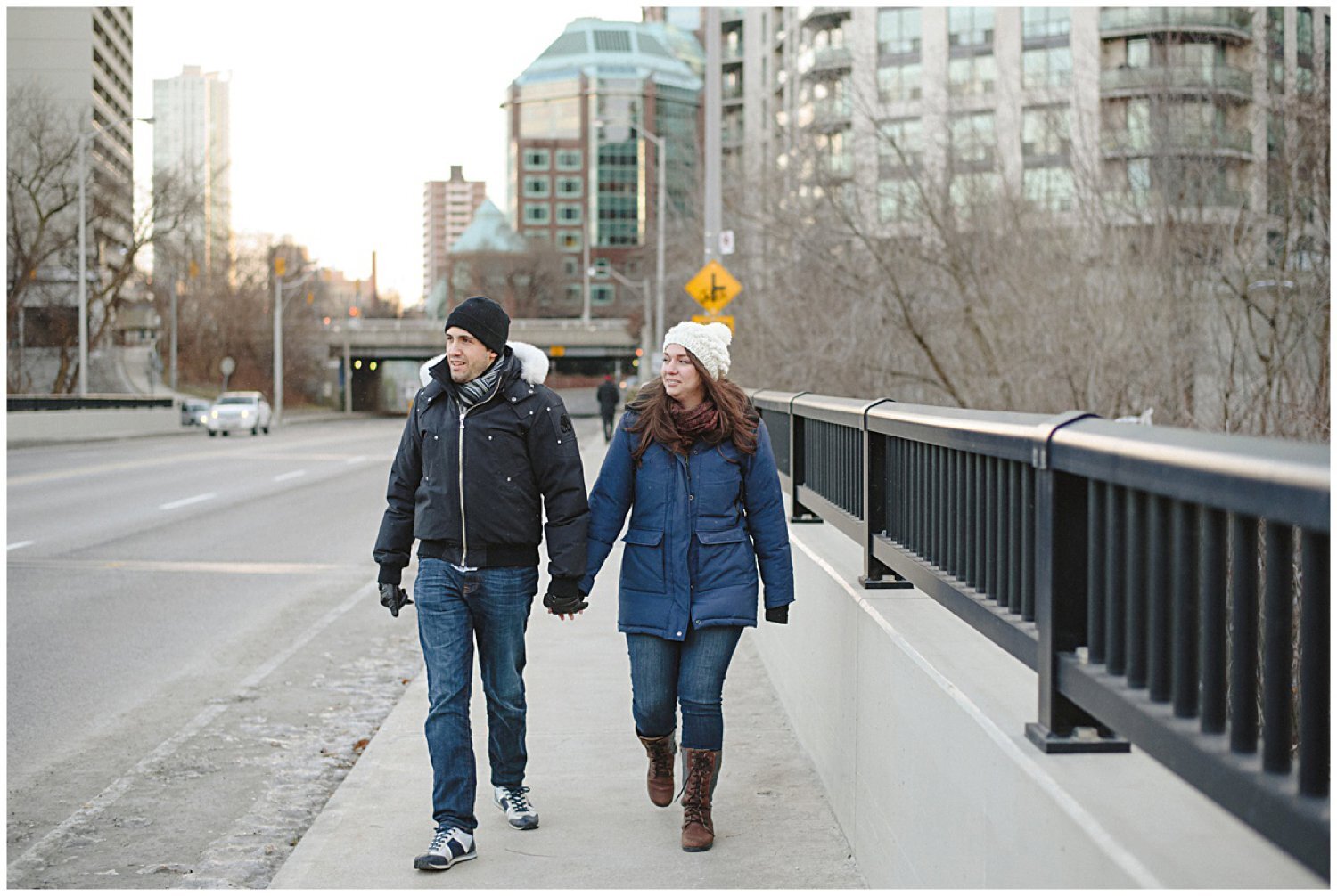 couple walking down the street holding hands toronto engagement session 