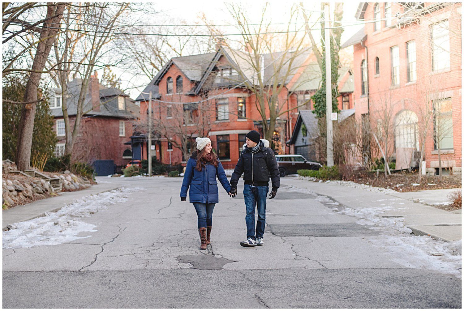 couple walking down the street holding hands toronto engagement session 