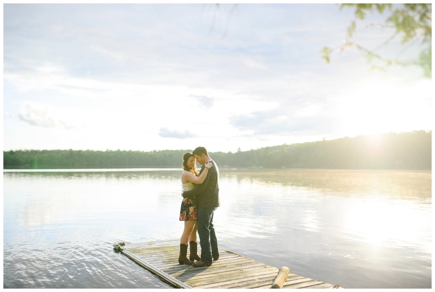 Couple kissing on a dock at sunset Muskoka engagement