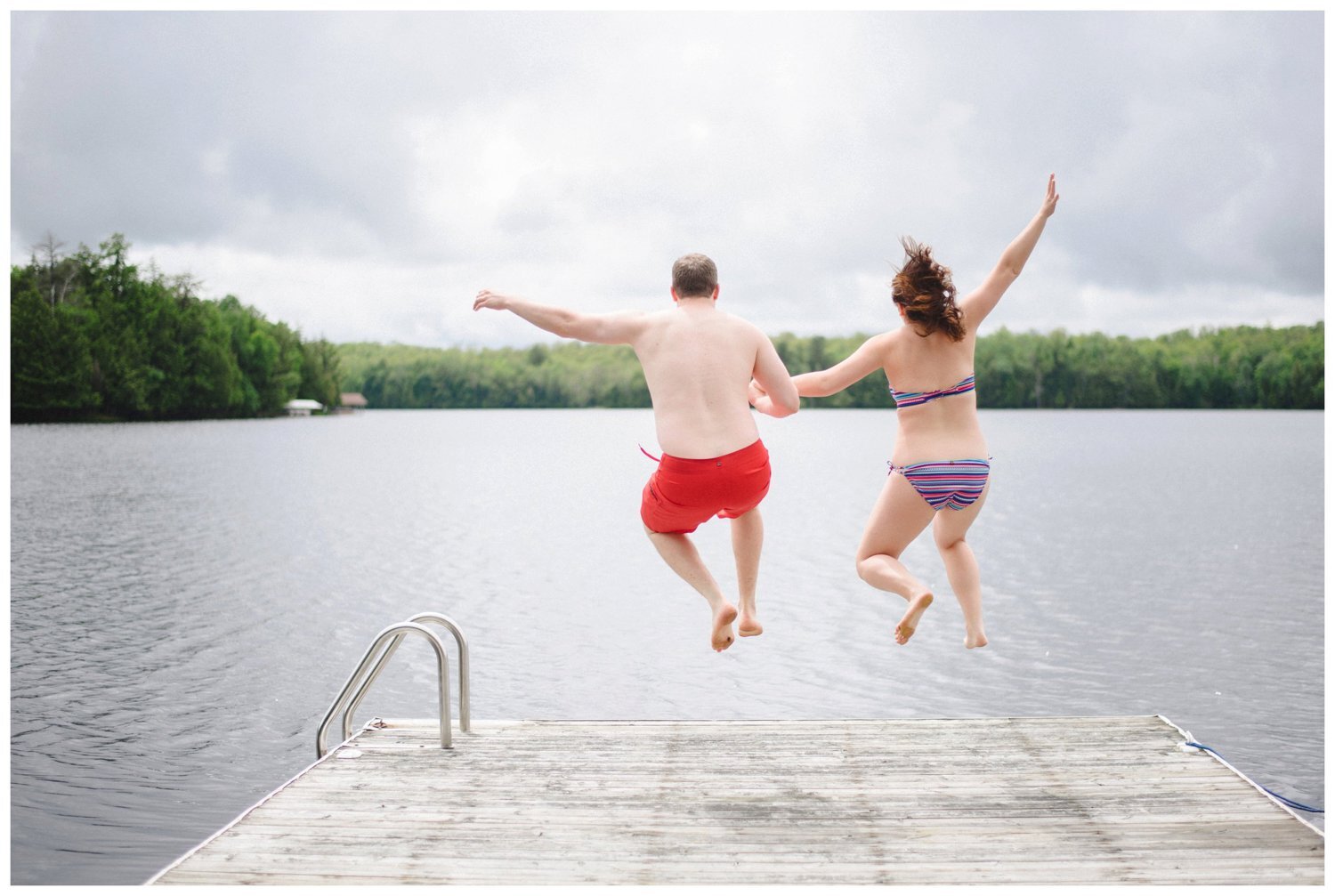 couple jumping into the lake Muskoka engagement