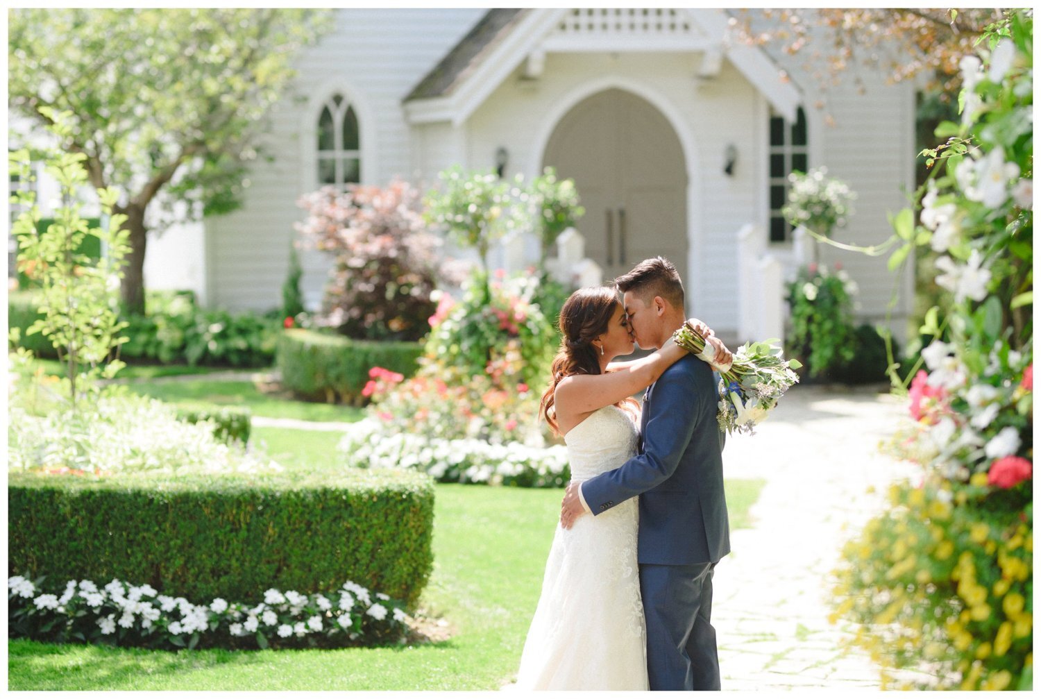 couple kissing in front of chapel at Doctor's House Wedding