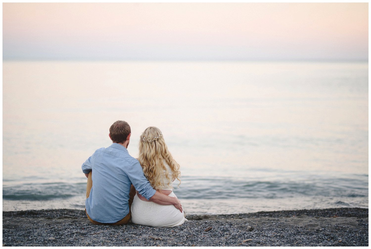 couple sitting on the beach at Scarborough Bluffs engagement 