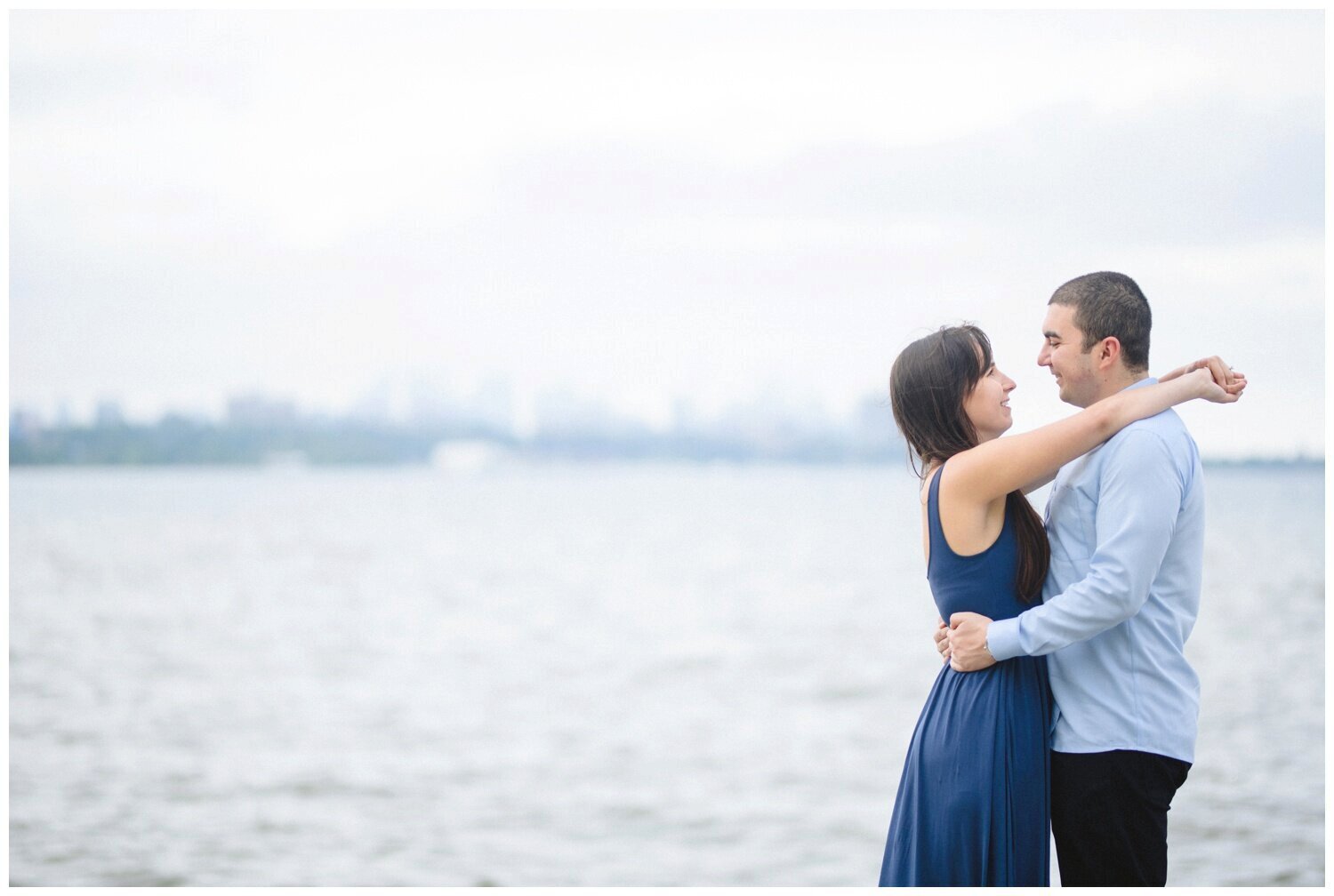 couple by the water with Toronto skyline Toronto Lakeshore Engagement 