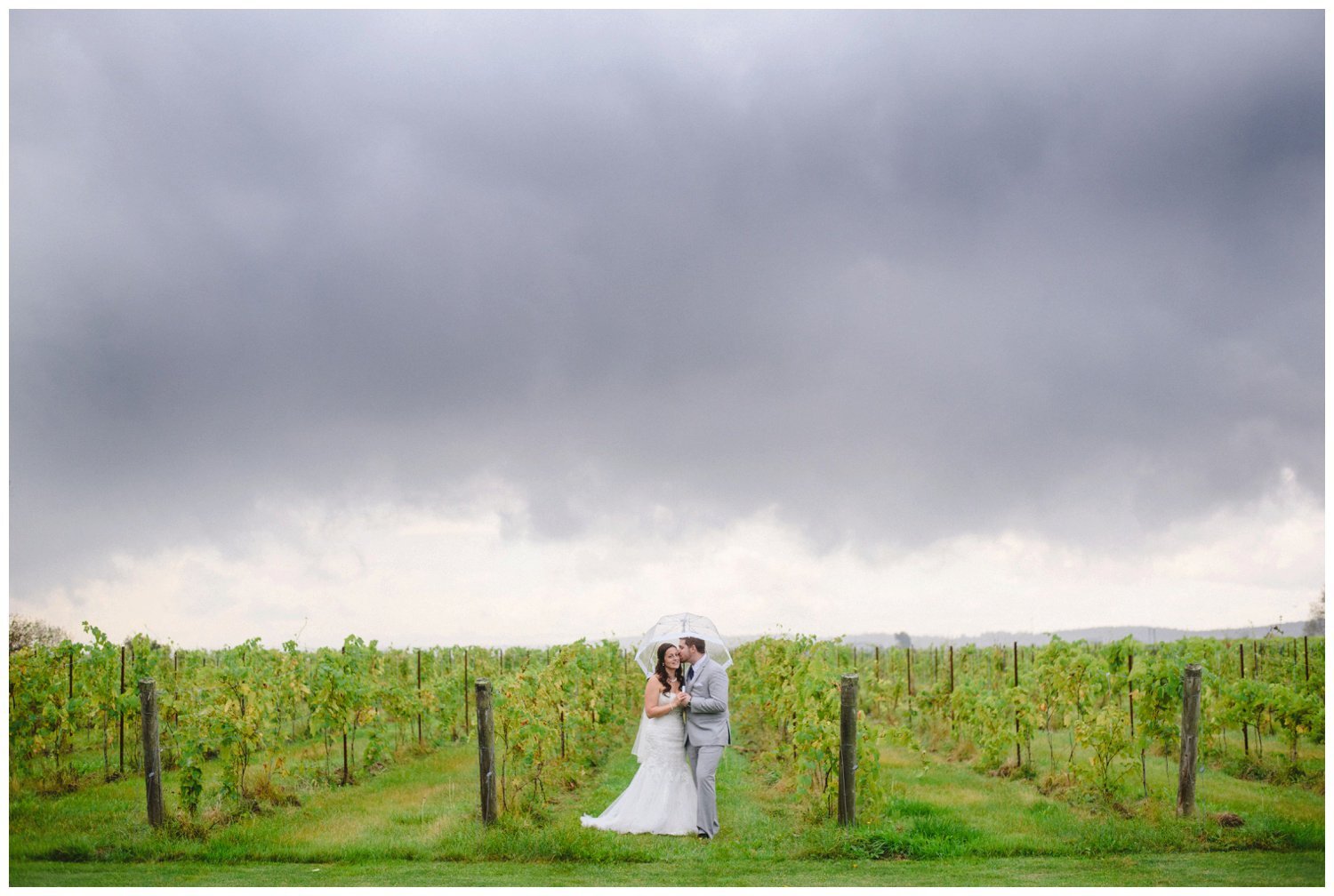 bride and groom kissing under a stormy sky at Holland Marsh Winery Wedding in Newmarket