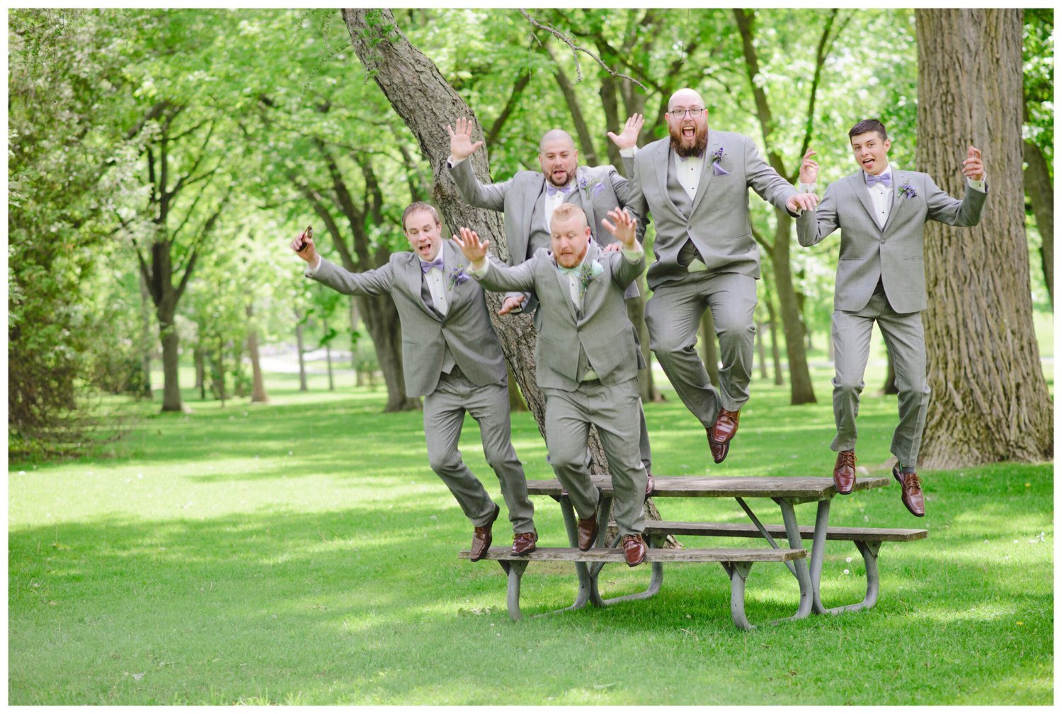 groomsmen jumping off a picnic table at Tosca Banquet Hall Wedding in Oshawa