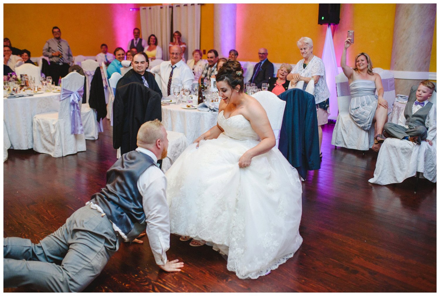 groom retrieving the garter at Tosca Banquet Hall Wedding in Oshawa