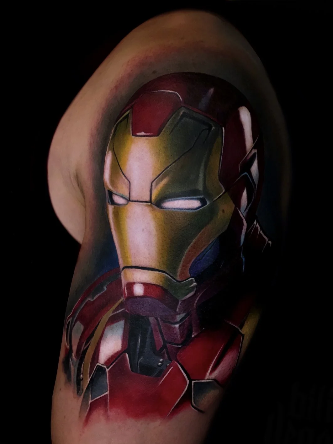 Tattoo of Iron Man's helmet on person's upper arm.