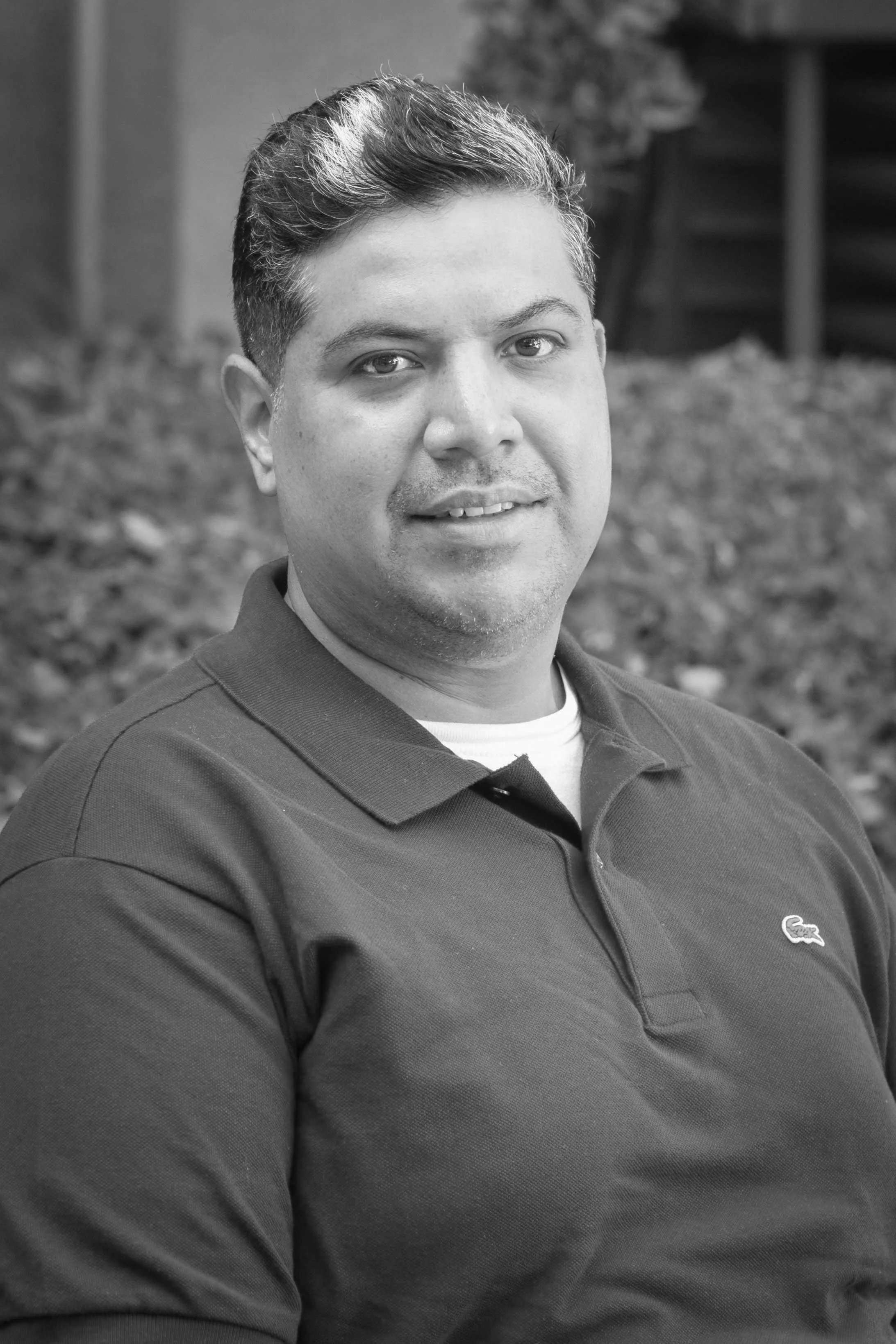 Black and white photo of smiling Latino man.
