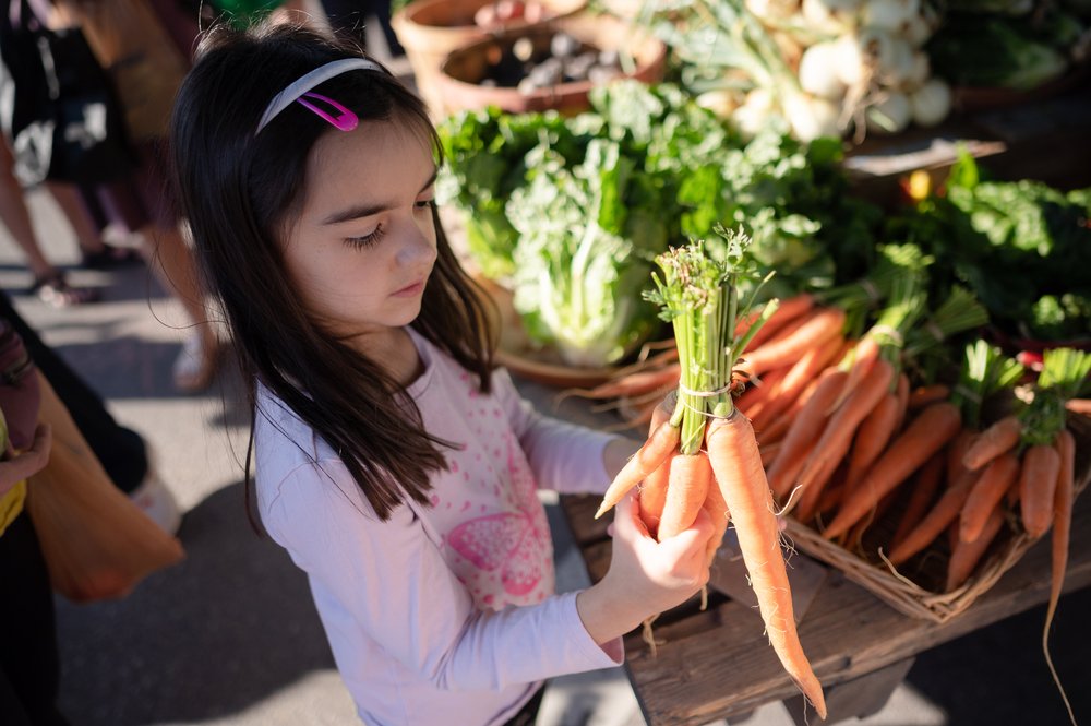 Lenon's daughter, Naomi, admires a carrot.