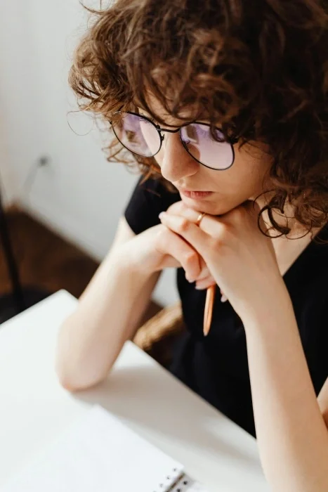 A woman with glasses looking sad.