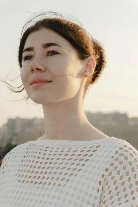 A woman looking forward with a small smile one her face.