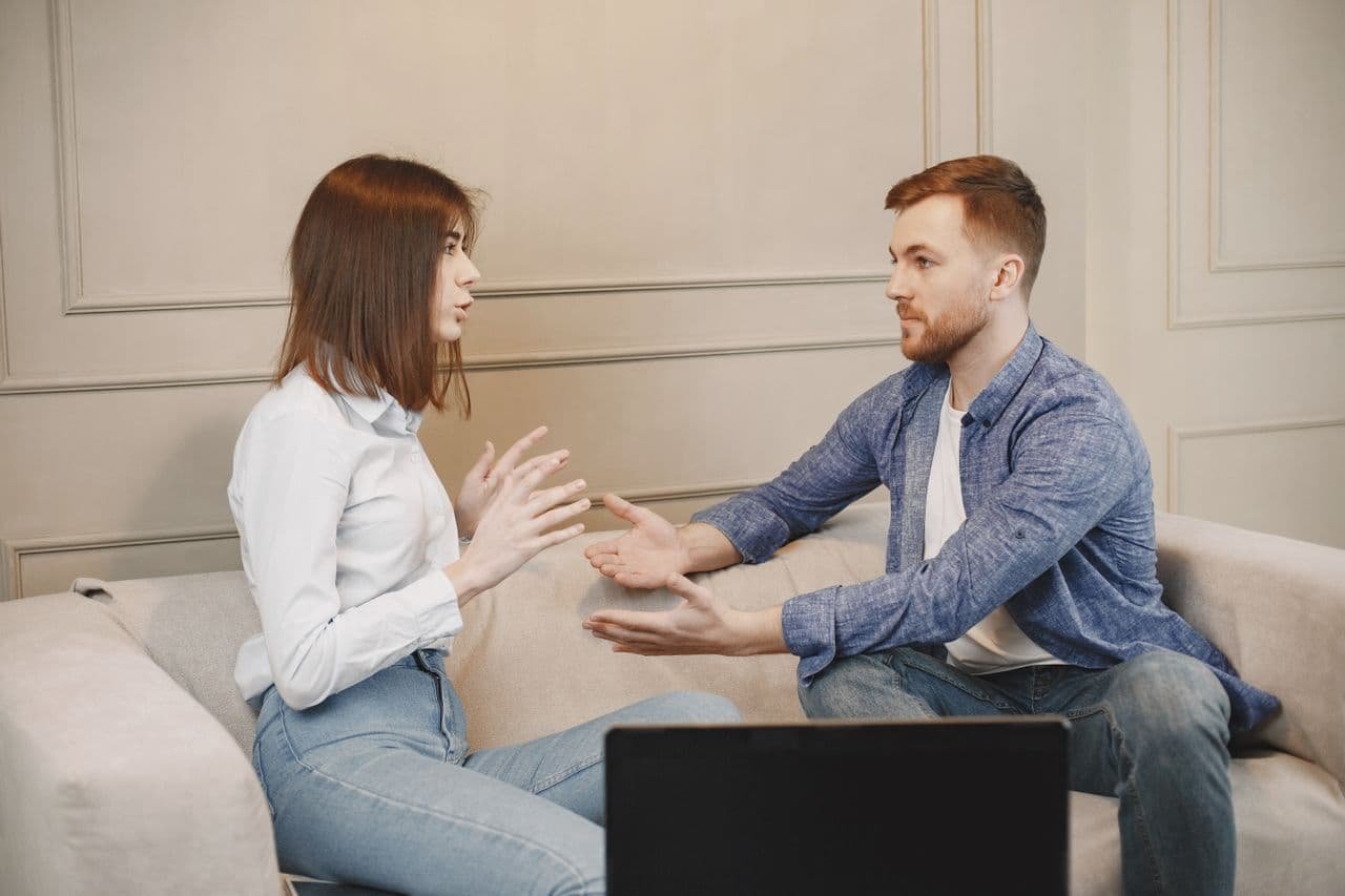 close-up-shot-of-a-man-and-a-woman-talking-while-sitting-on-a-couch
