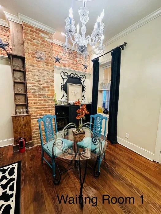 A waiting room with a bistro under a chandelier.