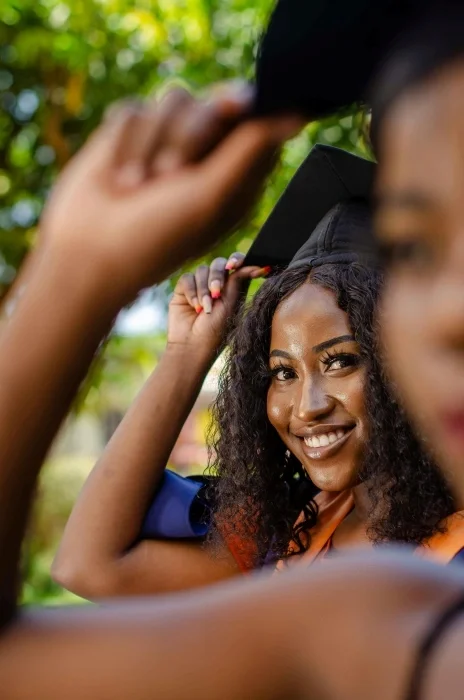 A woman smiling at her gradation ceremony.