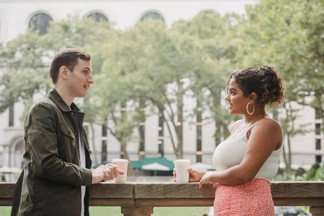 young-diverse-students-drinking-coffee-to-go-in-campus-park