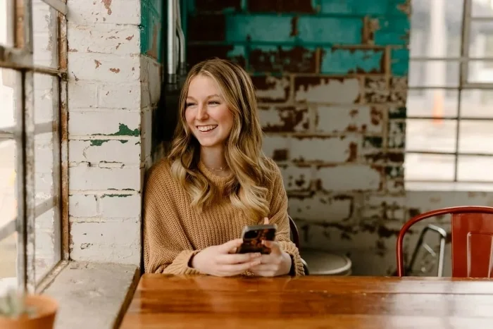 A woman smiling in a coffee shop.