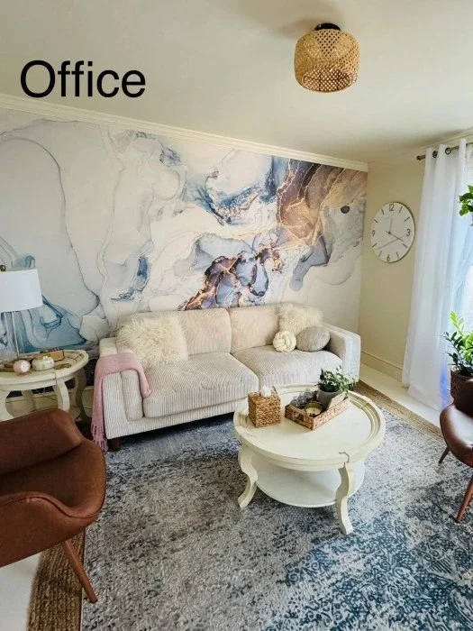 An office with marble wall paper, a cozy couch and natural decorations.