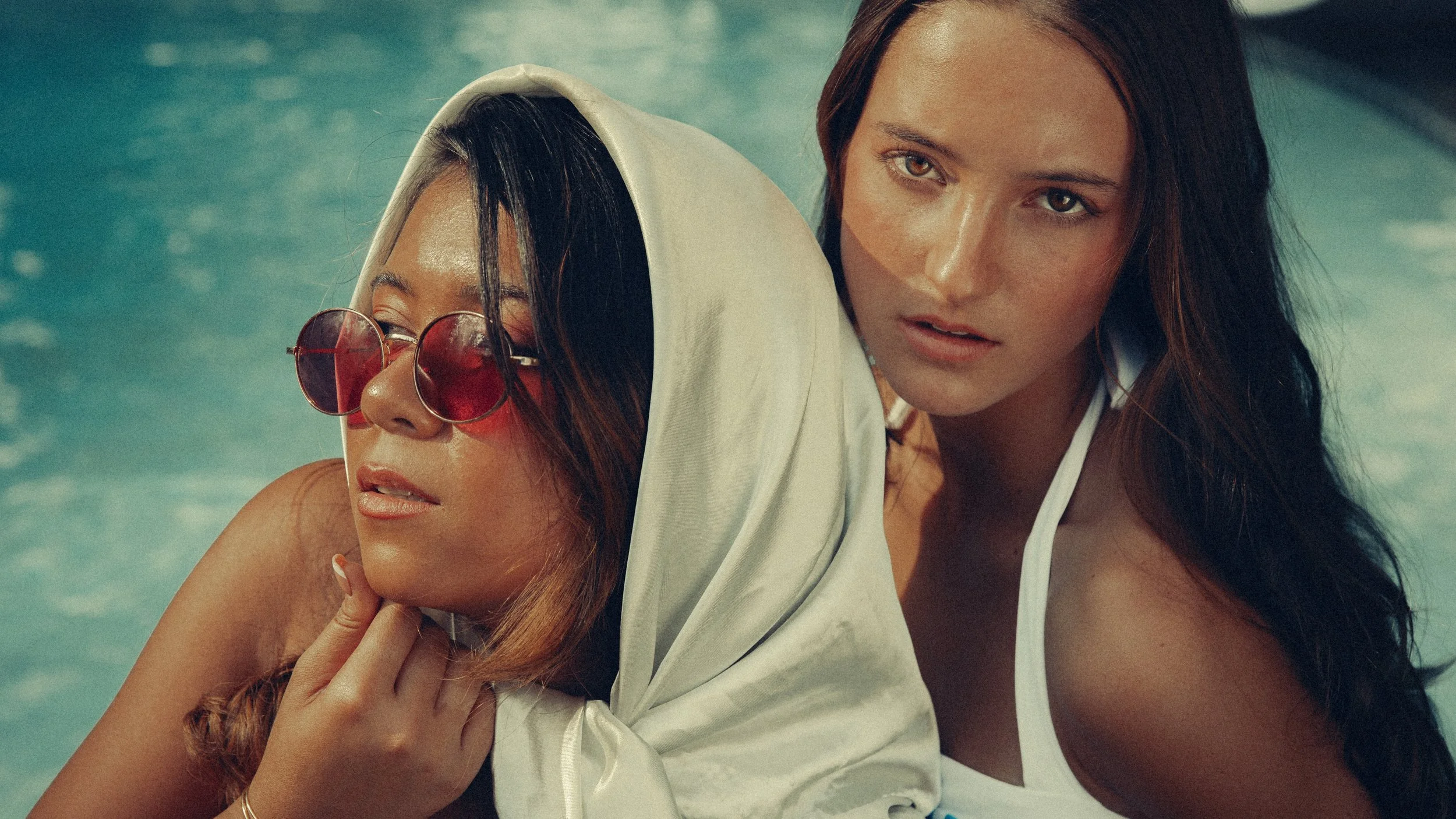 Three models in colorful vintage swimsuits at a 1970s-inspired backyard pool party in Post Falls, Idaho.