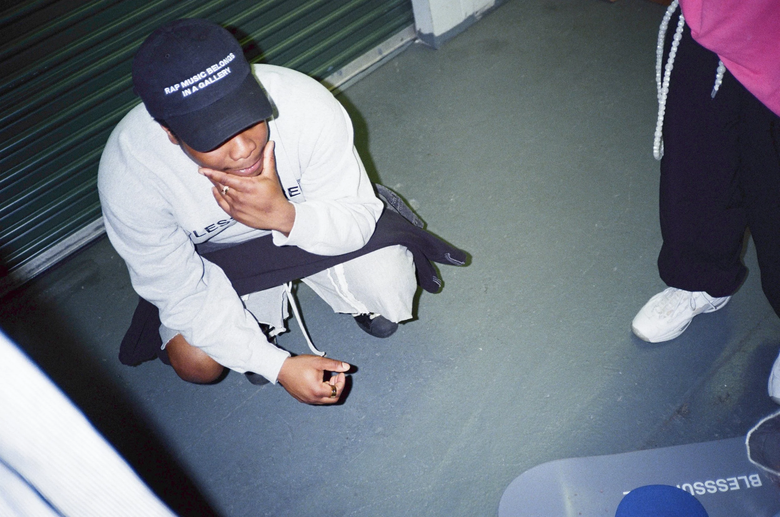 F1RST T1ME RAP MUSIC BELONGS IN A GALLERY black embroidered dad hat worn in a streetwear lookbook, showing the white lettering and low-profile curved brim.