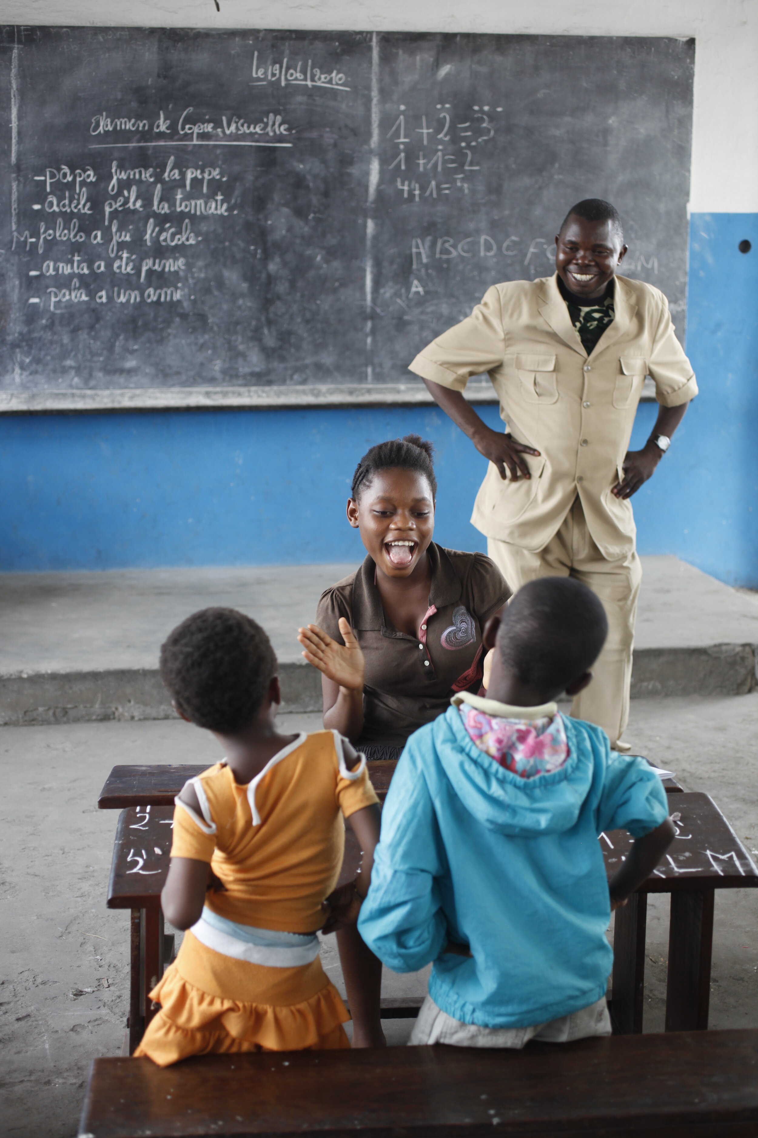  Director Alain Mayama with children Nomibatenda-Boongo Facitatrice, 14, Gracia, 5 and Samaela, 5 in the child to child program at Complexe Scolaire Saint Jean Boscu where 5th and 6th grade students work with 5 year olds in Kinshasa, Democratic Repub