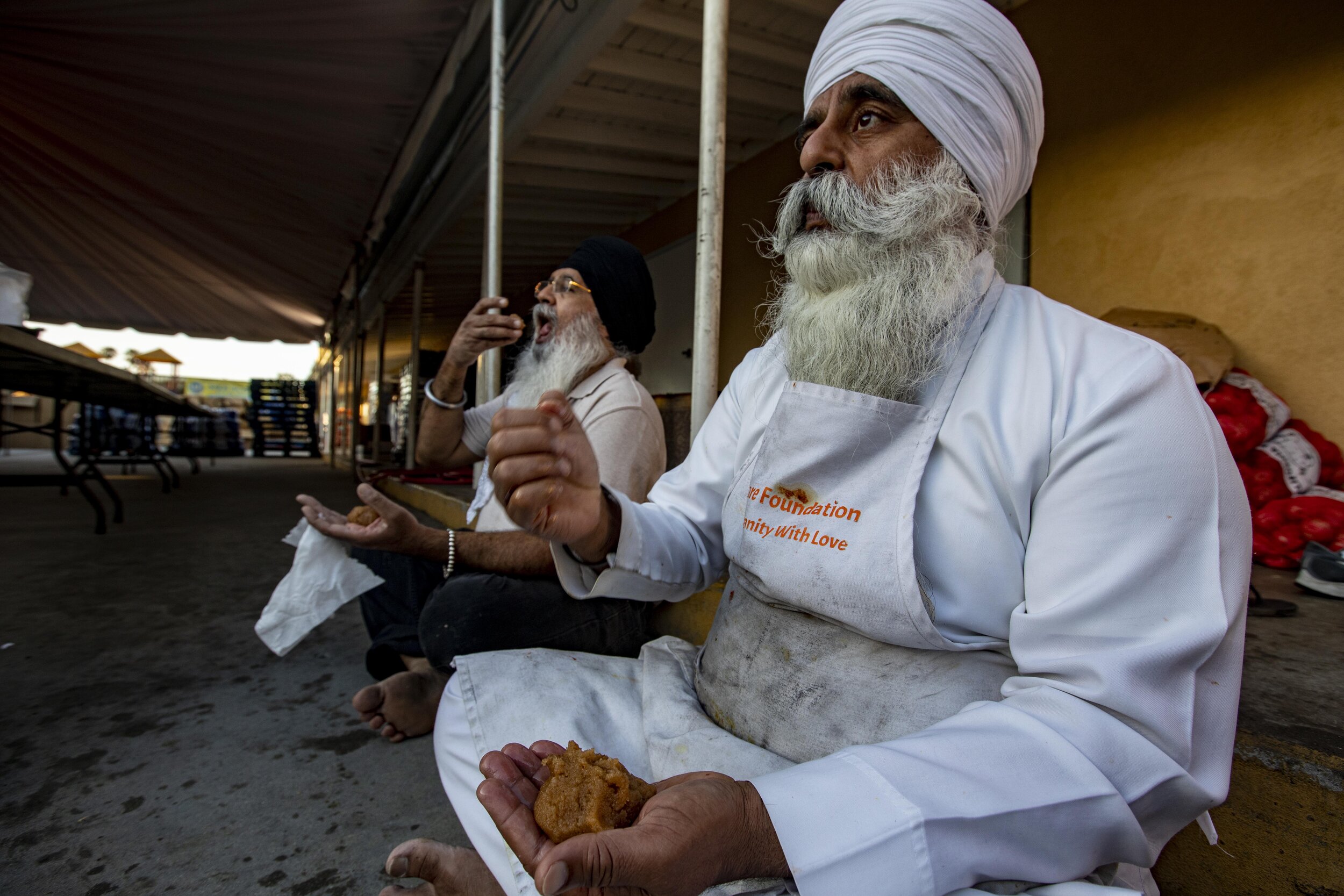  Manjeet Singh eats a traditional Sikh sweet called prashad at Khalsa Care Foundation during a break from preparing meals for the needy. The Sikh tradition is that the desert be eaten by hand sitting on the ground in the gurdwara (temple). The Sikh c