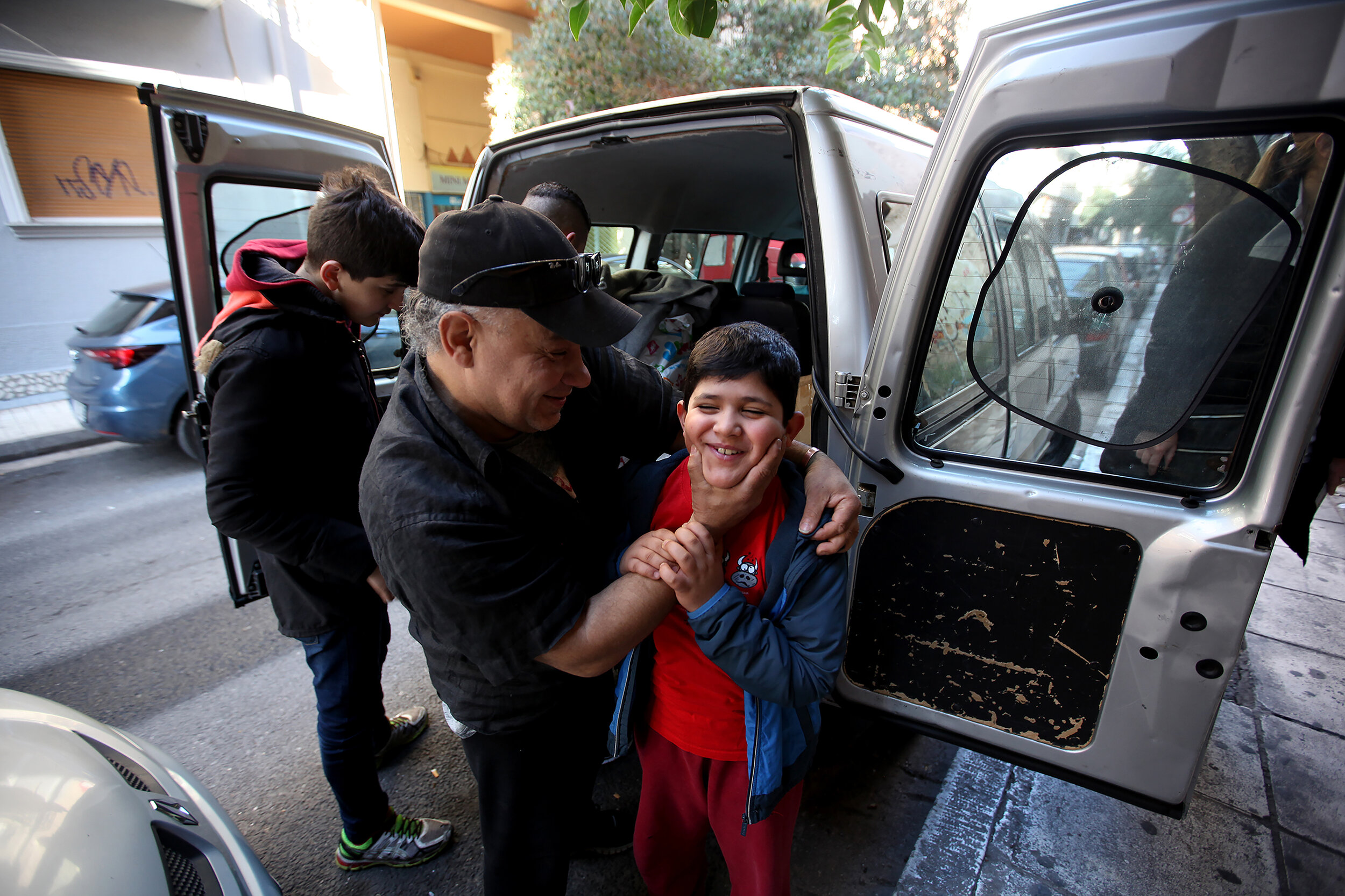  Allied Aid volunteer Fadi Sayde jokes around with one of the children outside Hope Cafe as they unload items donated by Allied Aid to Hope Cafe, for refugees in Athens, Greece. 