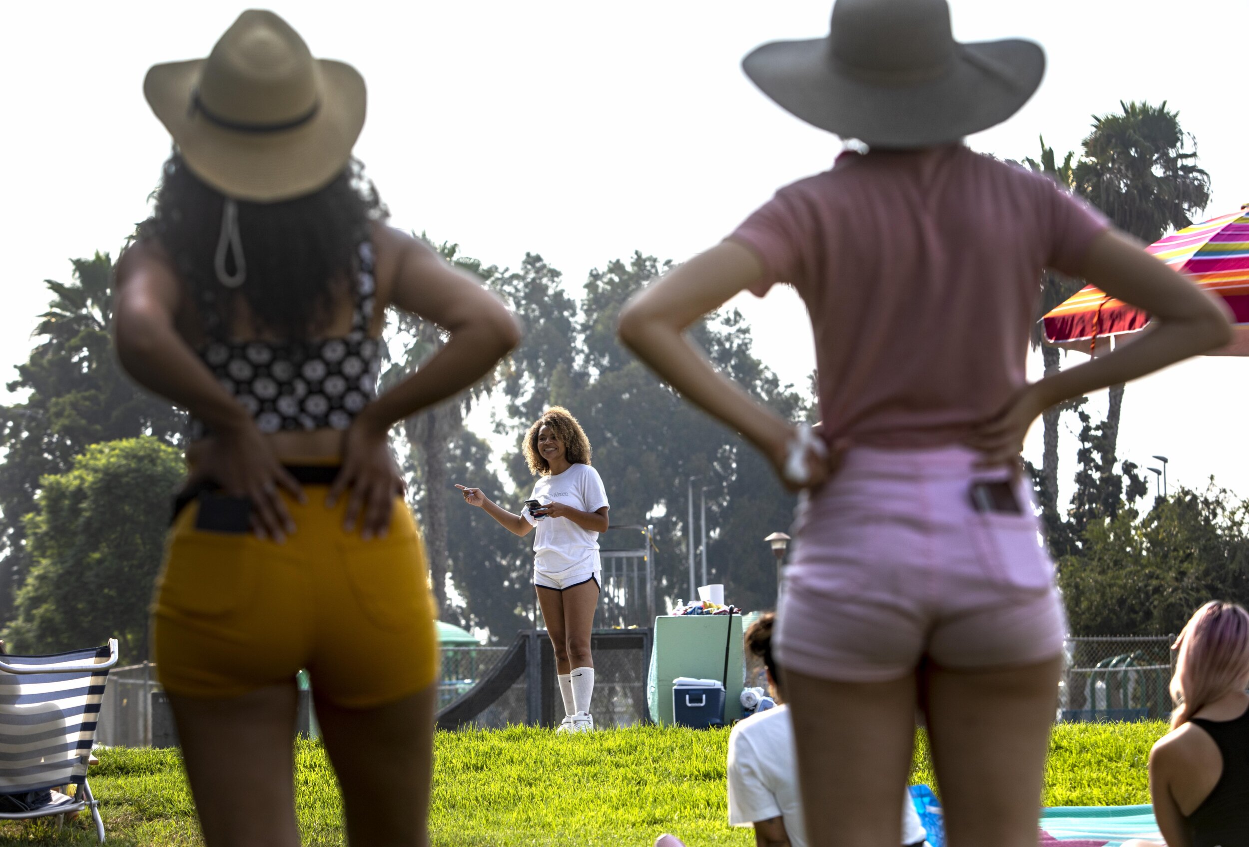  Actress and poet Yazmin Monet Watkins recites some of her work as Frances McGee ( known by her skate name of Abominatrix) and Ariana Chavez (known by her skate name of Cha Cha) listen at the "You Good Sis" event at Rogers Park in Inglewood, Calif.  