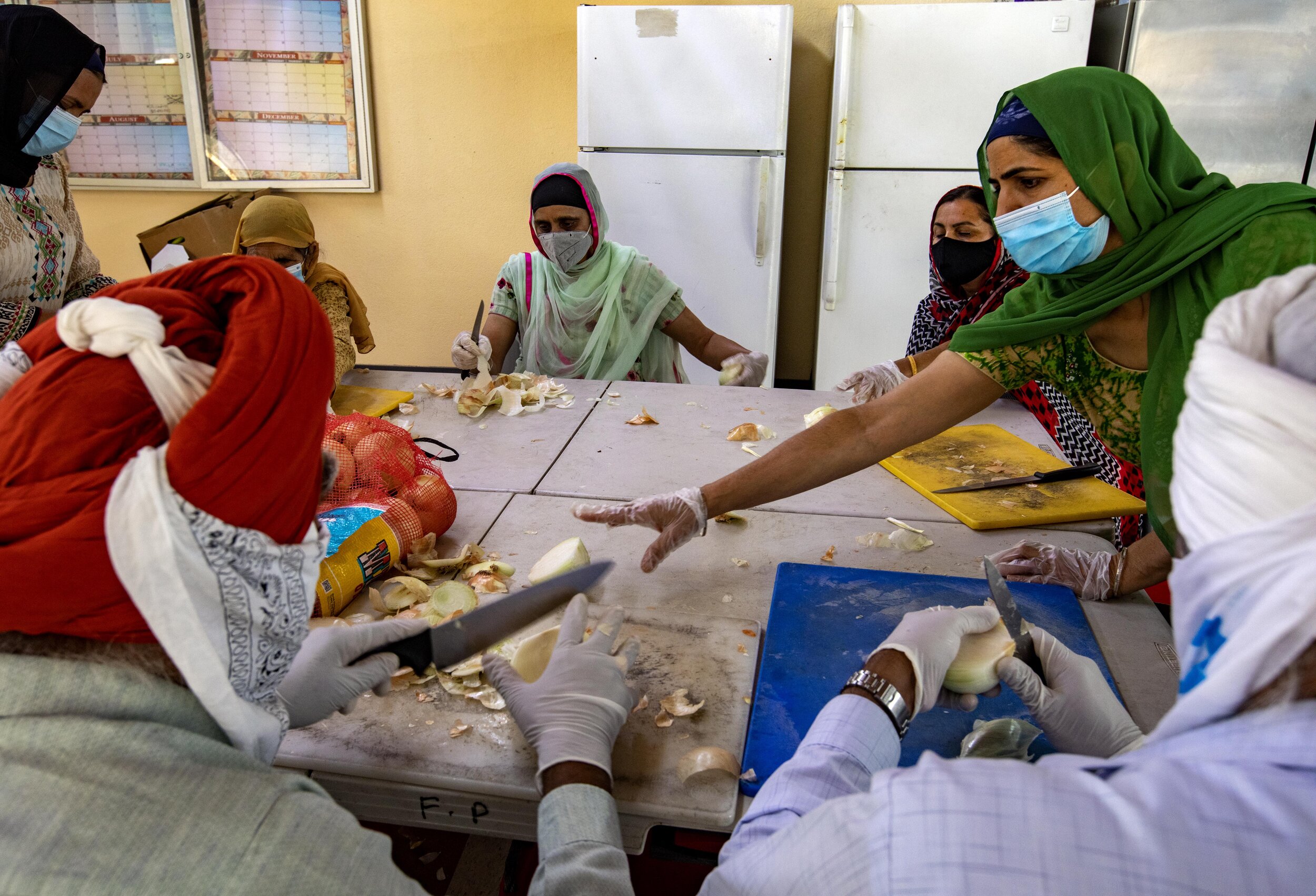  Amander Kaur (right) cuts onions and helps prepare food at Khalsa Care Foundation. The Sikh community in Pacoima is working with the Mayor's office and Department of Disability and serving 3,000 meals daily. They have 50-55 volunteers that show up M