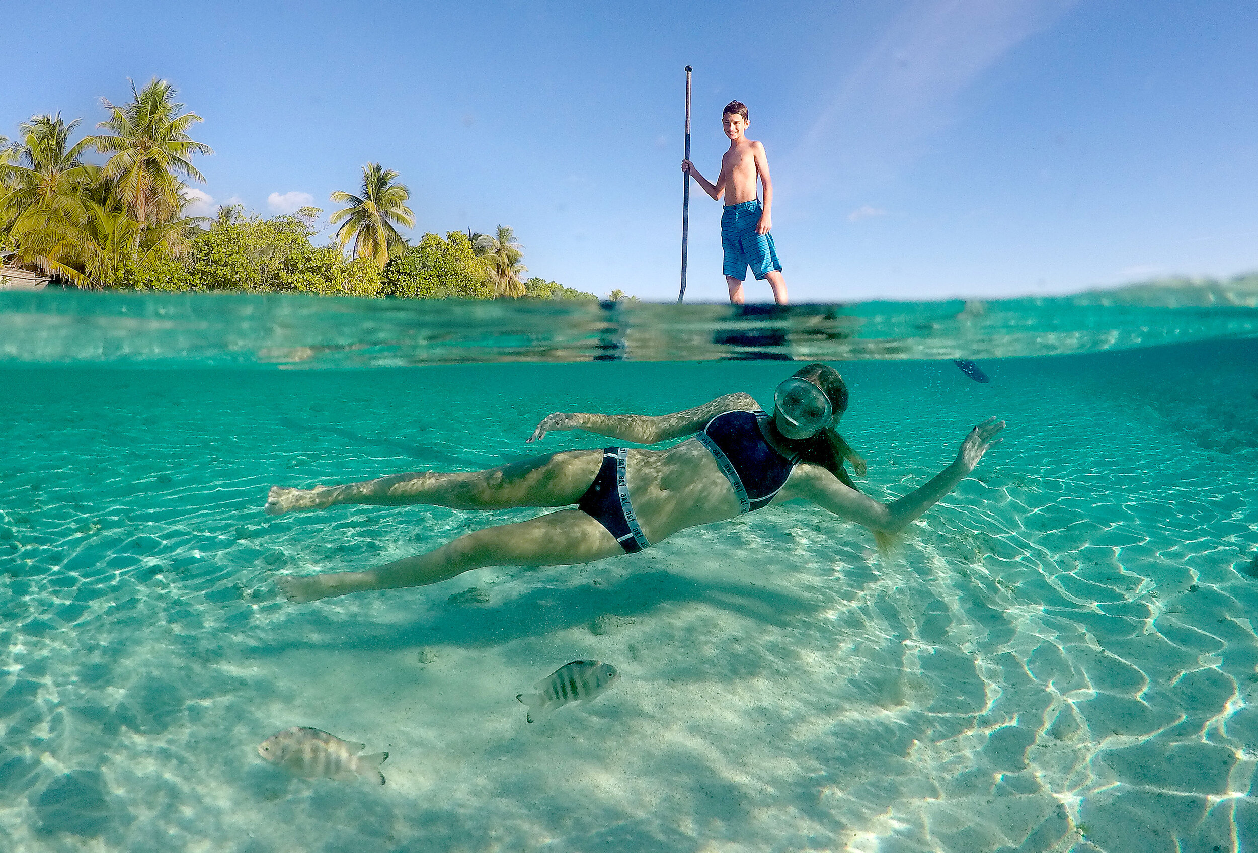  Jack van der Brug stands on a paddleboard while his sister Sierra swims underwater at Tikehau Atoll in French Polynesia. The atoll has the most fish species in French Polynesia.  