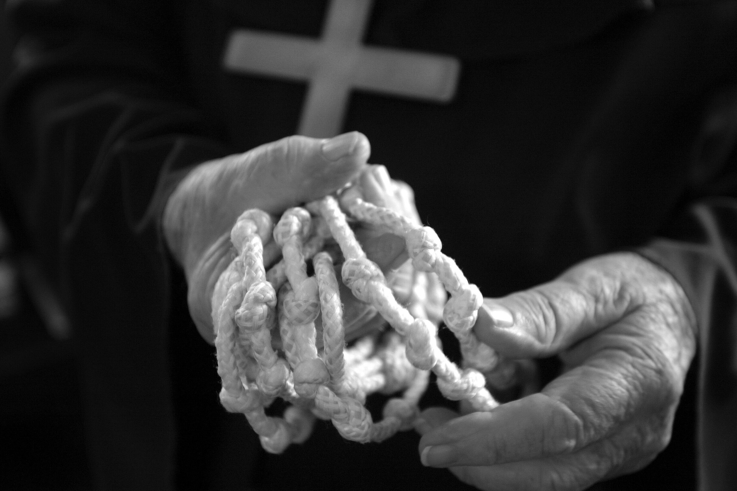  Harry Bartron holds a handmade rosary he made out of rope.  