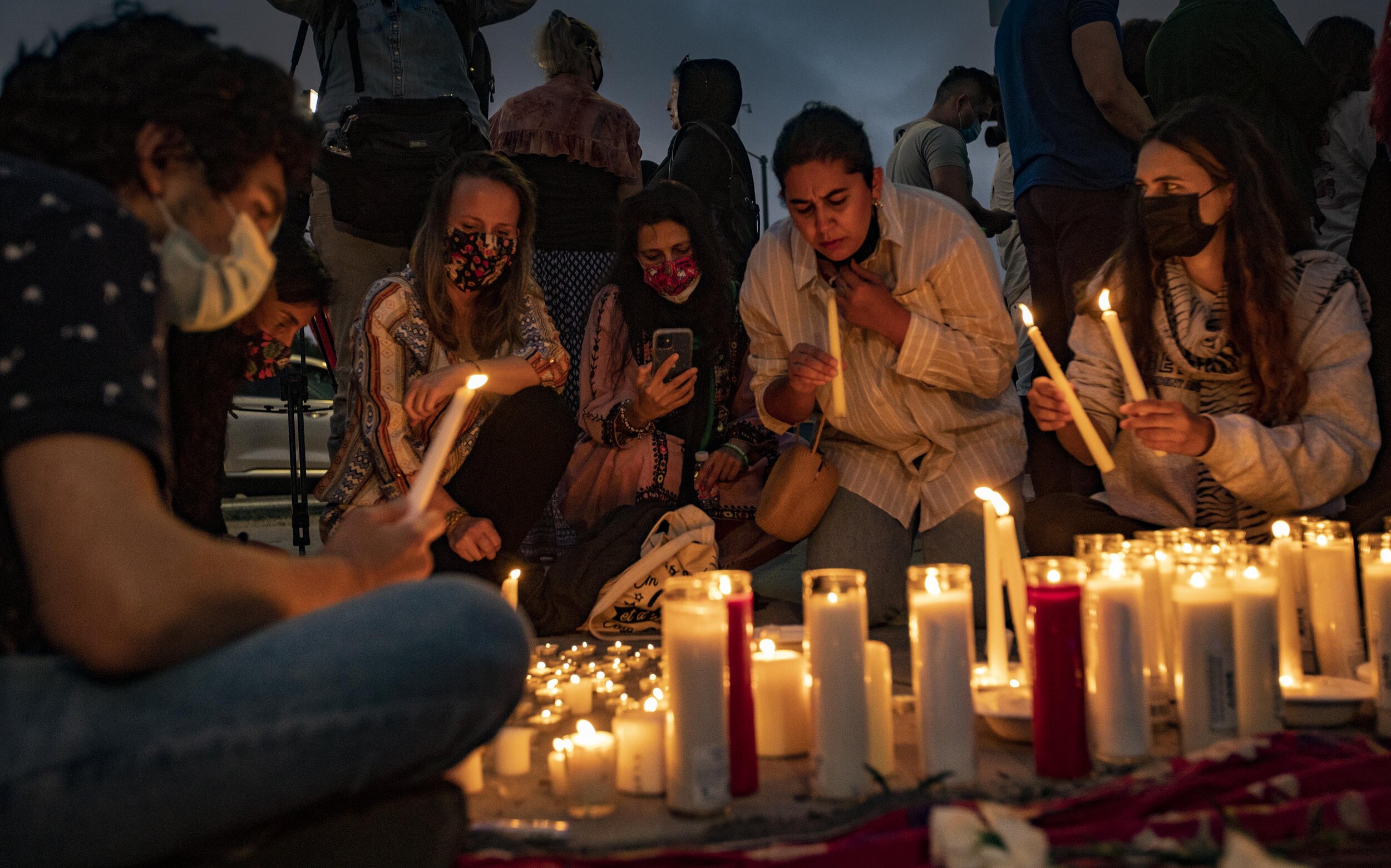Aryan Boomwal (left) and other members of the Los Angeles Afghan community hold a candlelight vigil outside the federal building in Westwood in response to the Taliban taking control of Afghanistan. 