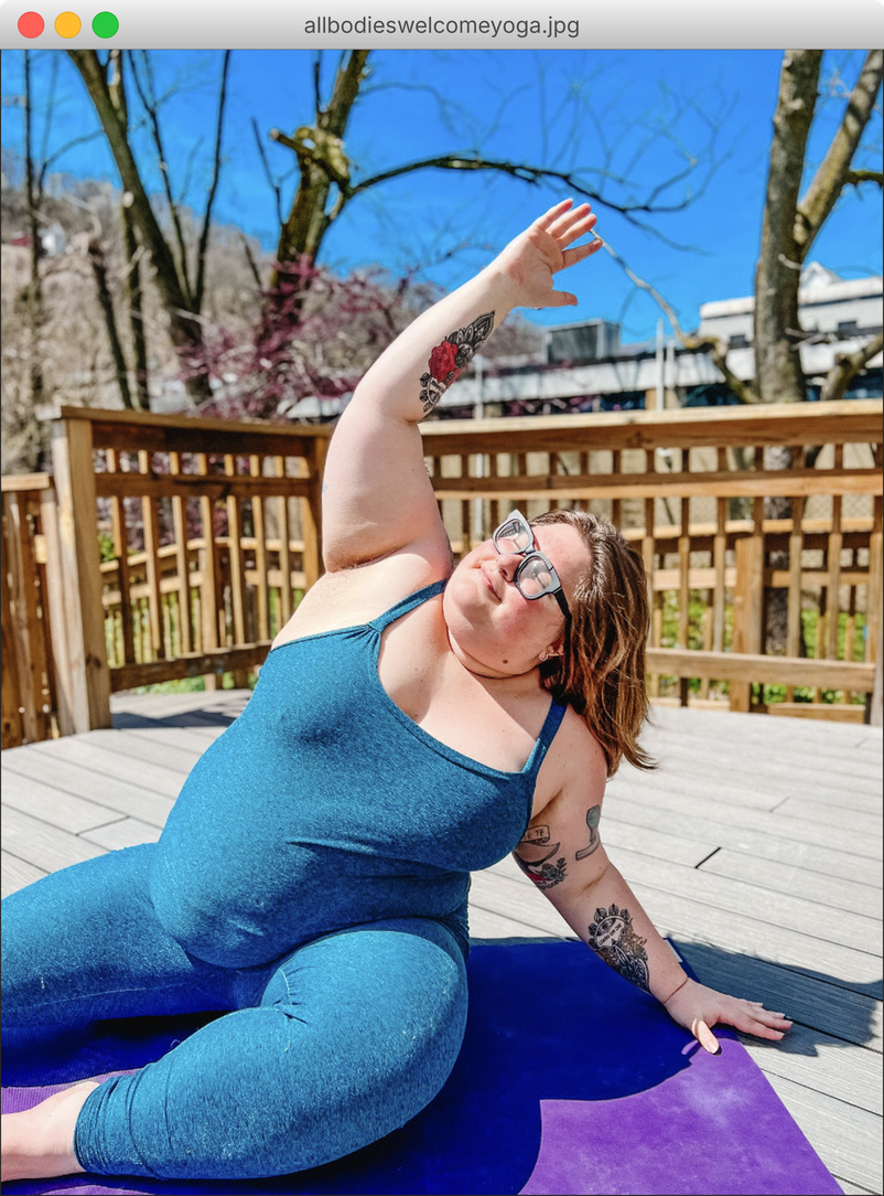 Emily Anderson in a side stretch on a purple yoga mat on a sunny deck