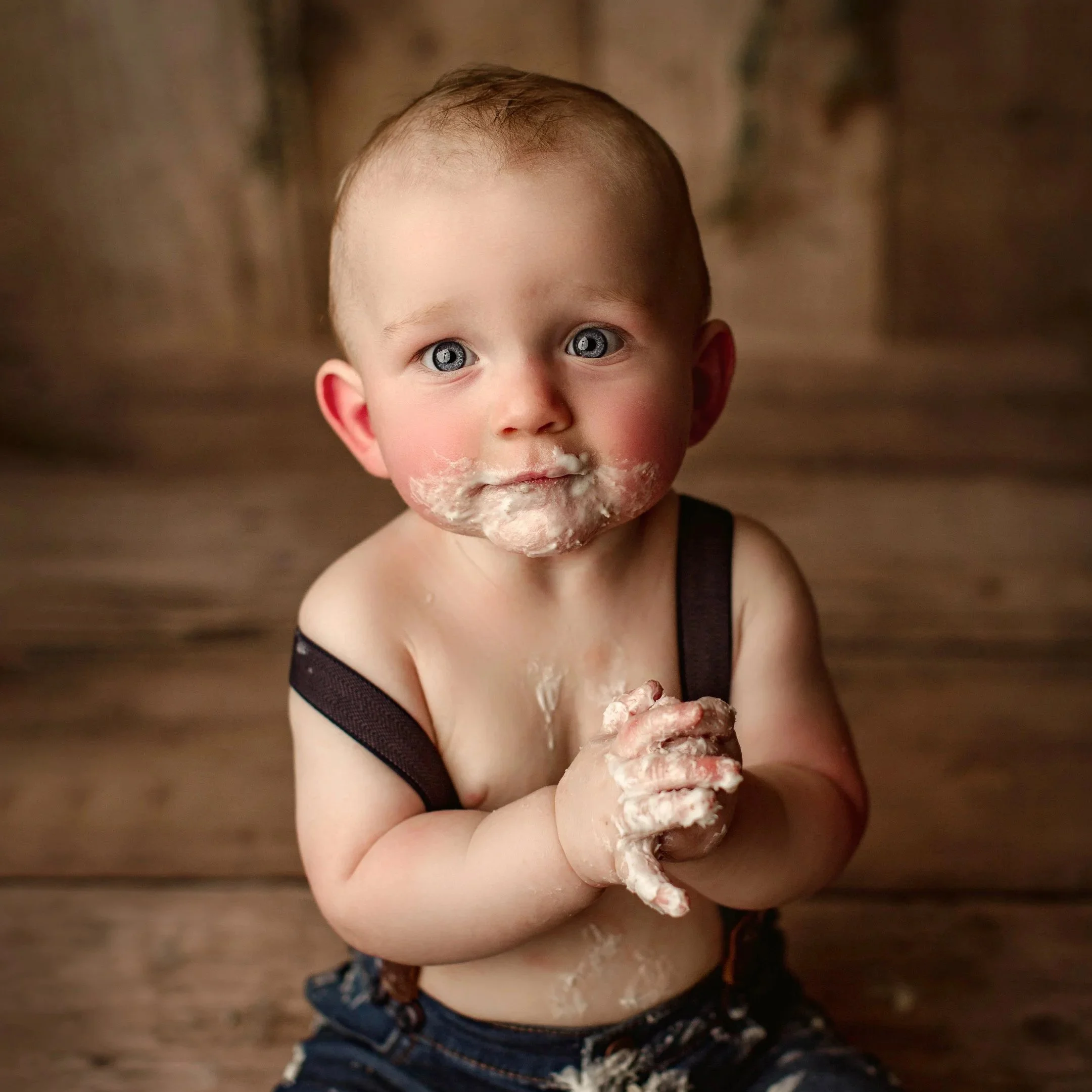 A one year old baby boy takes photoshoot cake smash pictures with a photographer from Vacaville and Fairfield