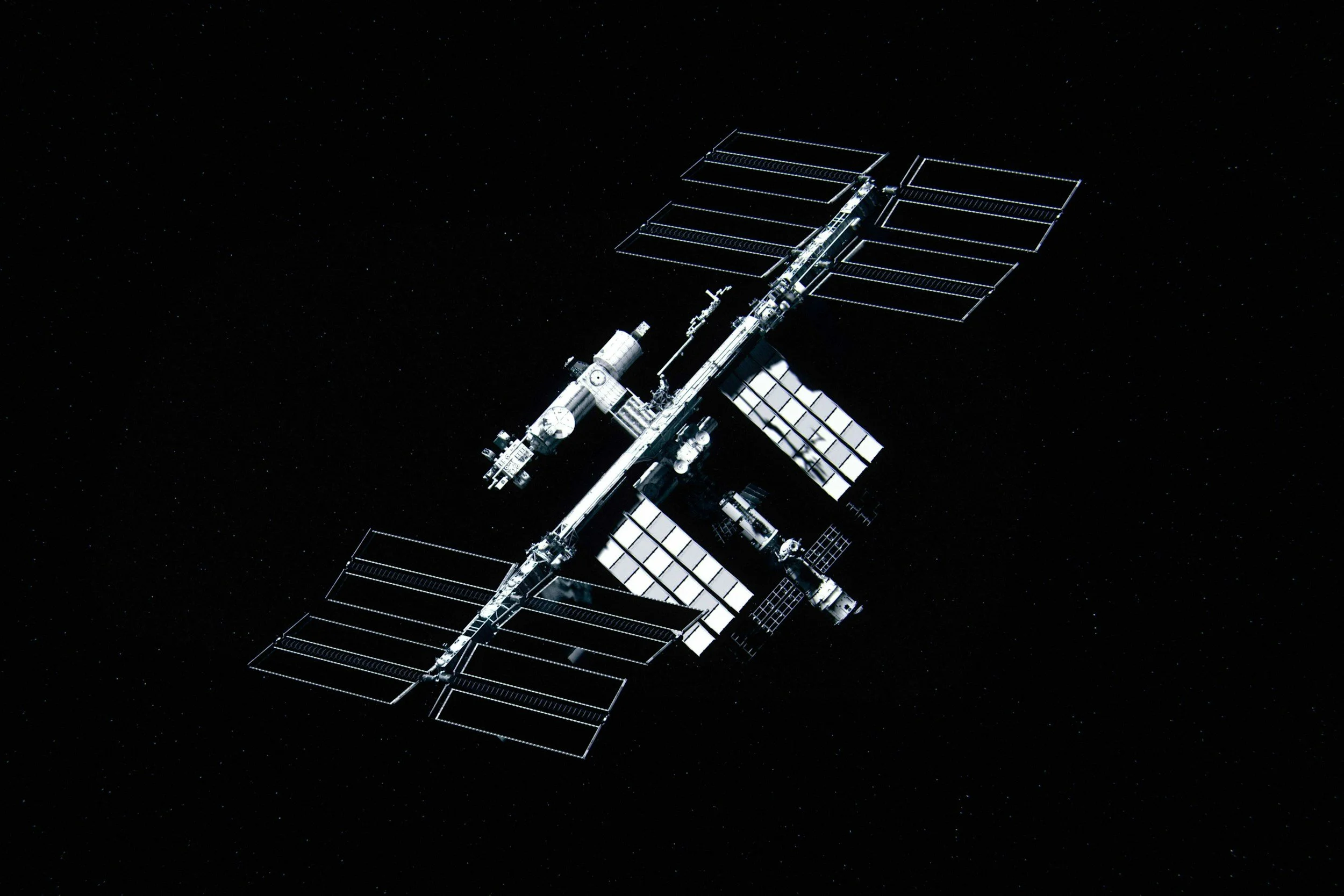 A space station or satellite with solar panels floating in outer space against a backdrop of stars.