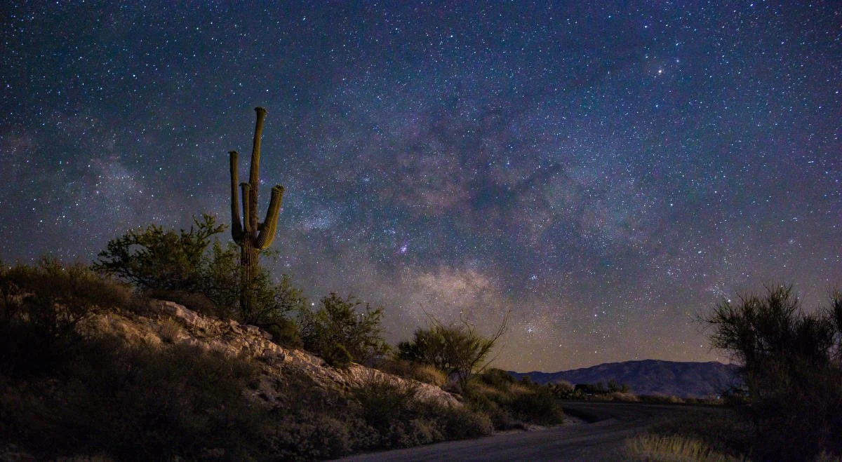 Comparison of Tucson city light pollution creating a yellow sky glow versus a clear Arizona desert night sky filled with stars and a visible meteor streak.