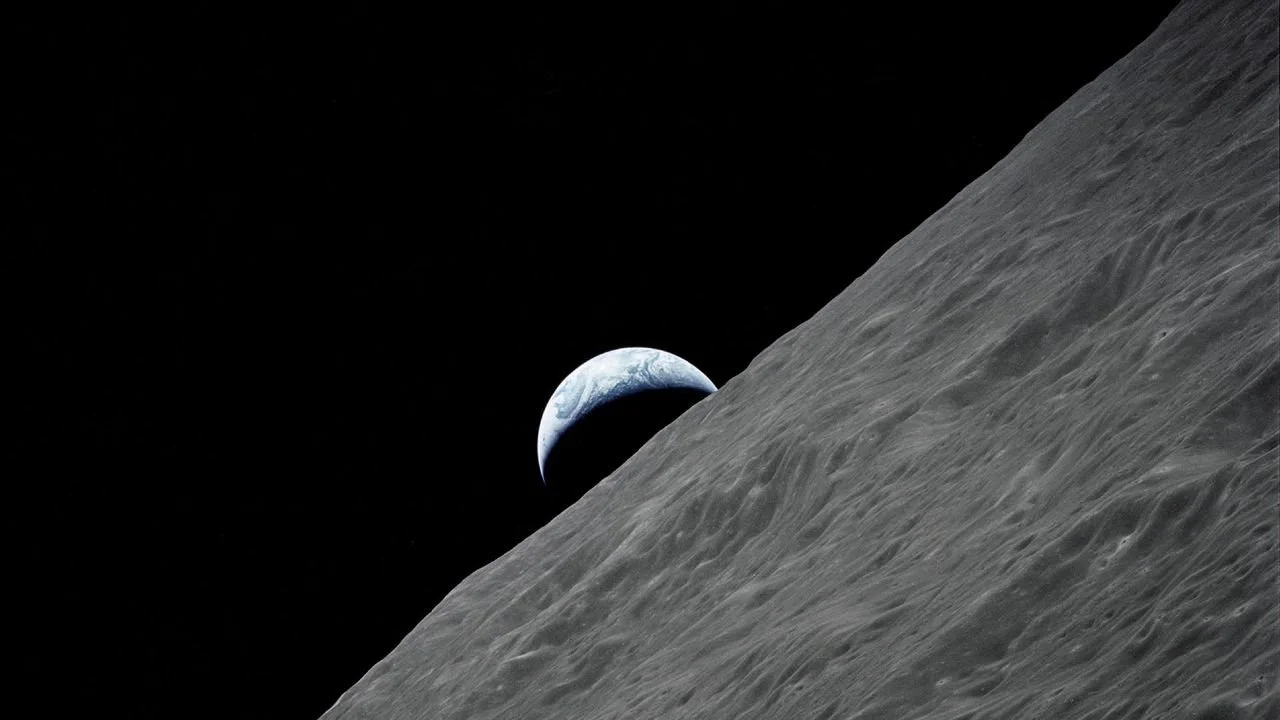 View of Earth from the moon, with the moon's surface in the foreground.