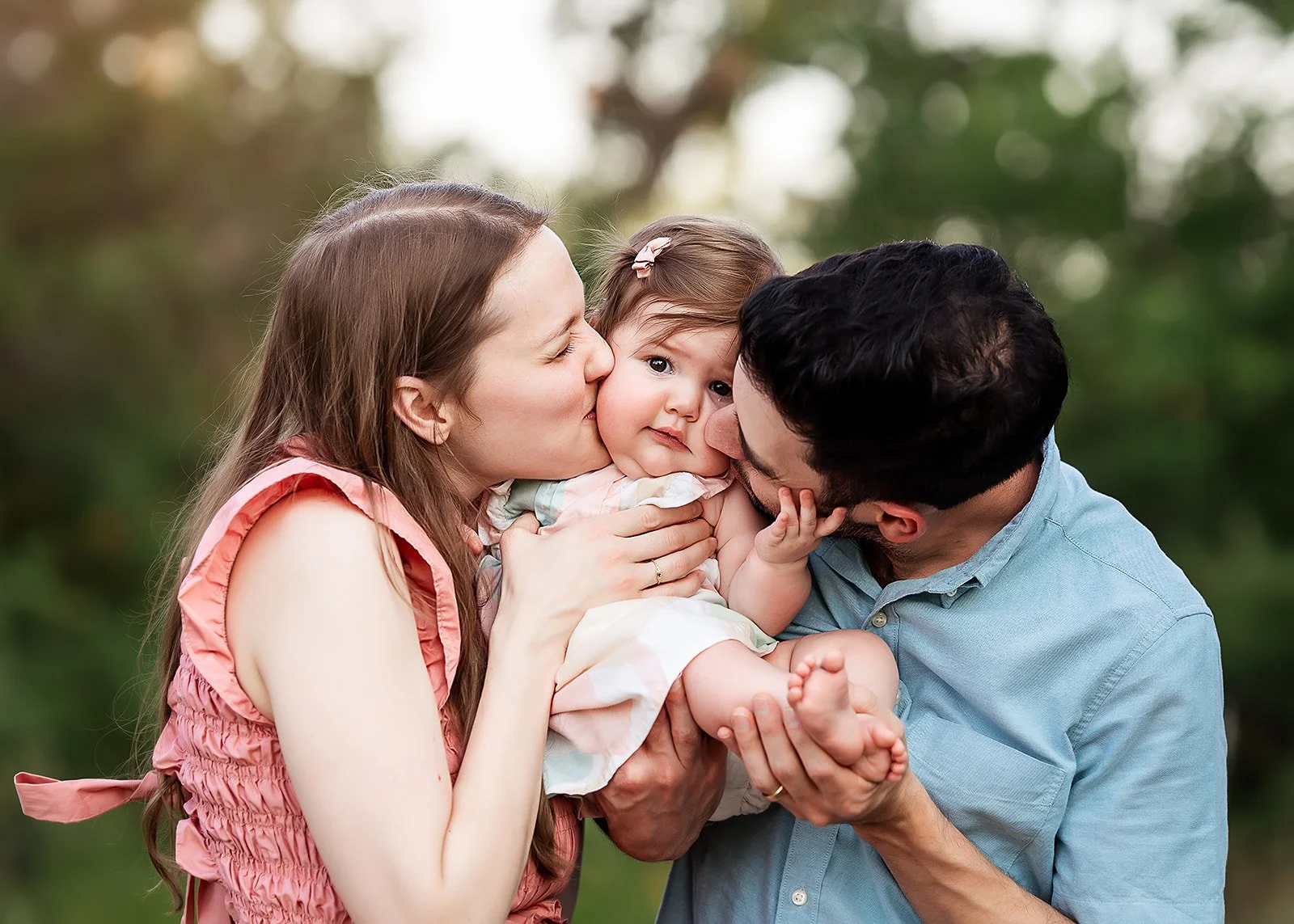 Parents kissing daughter at family session  - Circle C Park