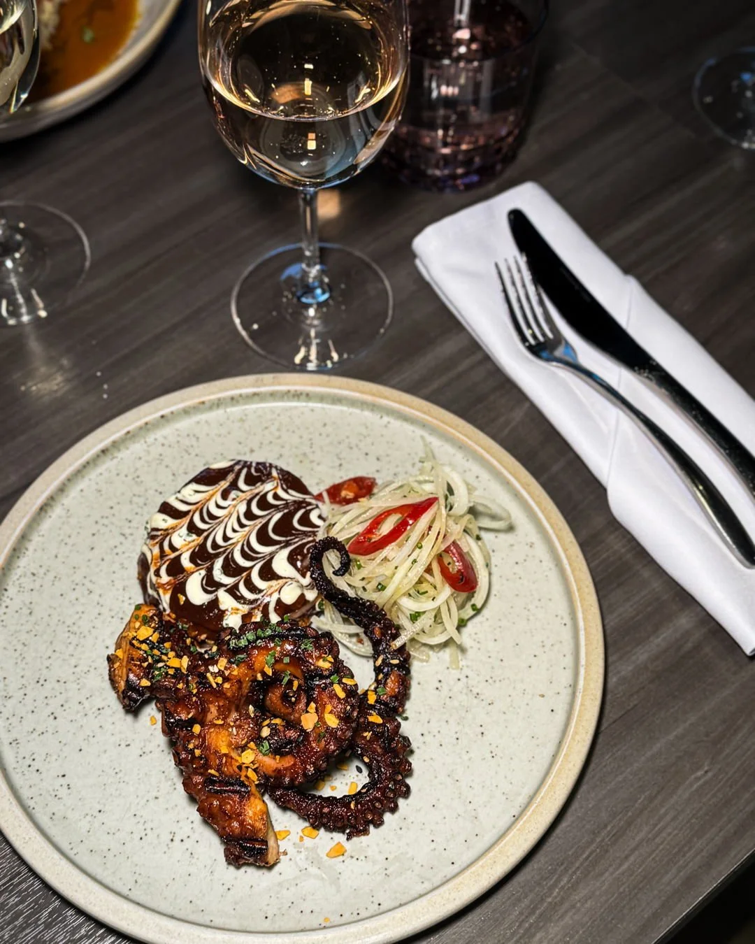 CHARRED OCTOPUS
okonomiyaki cabbage pancake, pickled finger chili, spiced octopus glaze, kholrabi slaw, kewpie, scallion, almond crunch 

It looks this good for a reason. Photo first, fork second🔥