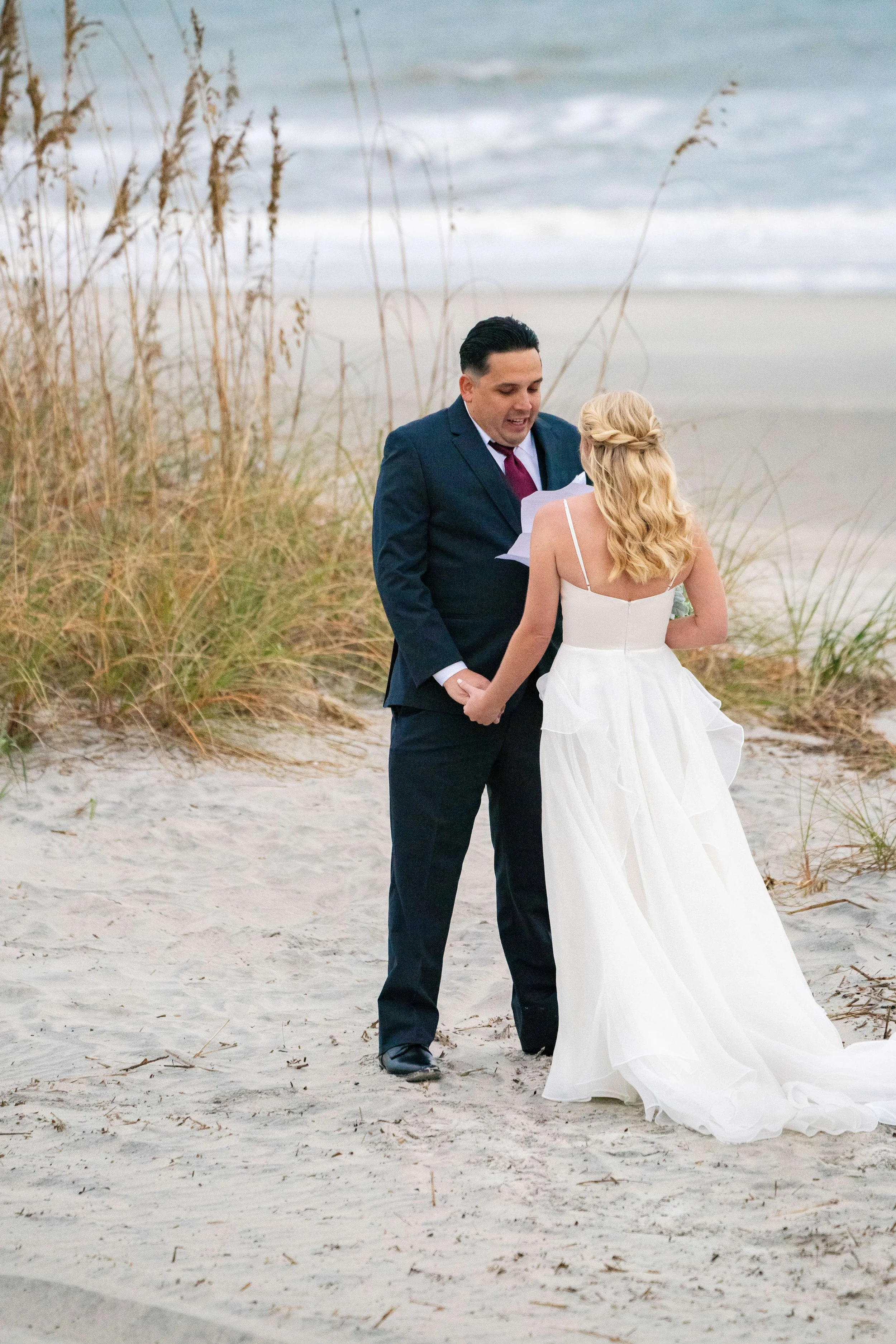 Groom reading vows in the dunes at a Hilton Head beach