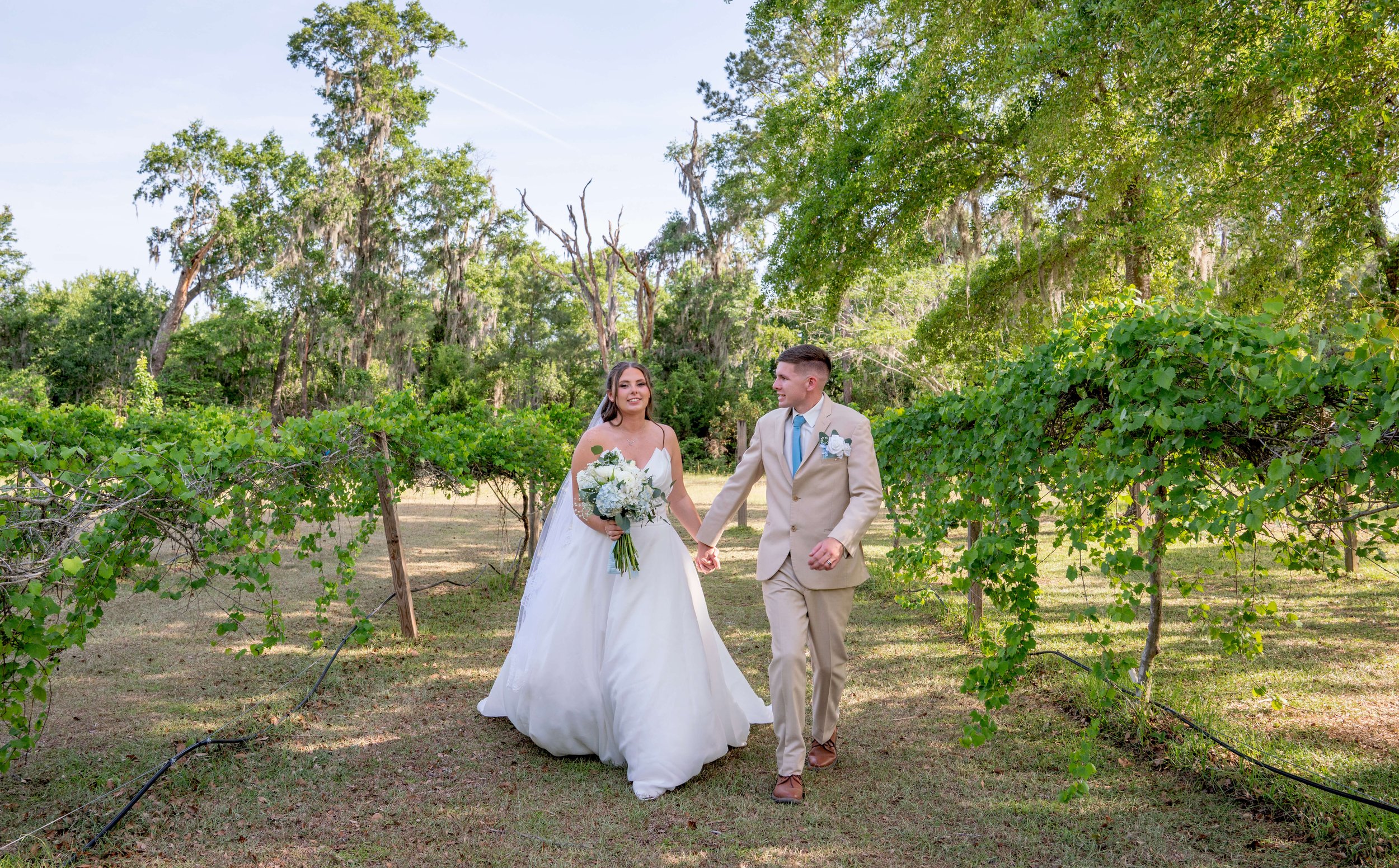 Bride and Groom walking in a field