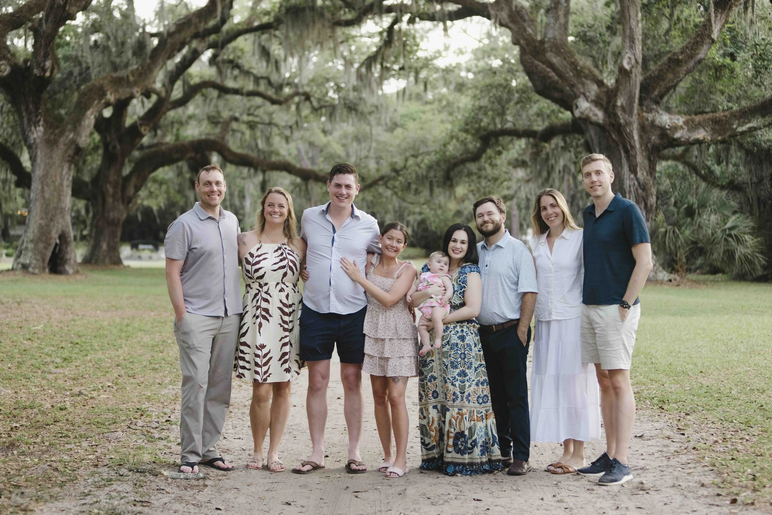 Family standing under large oak trees in Hilton Head