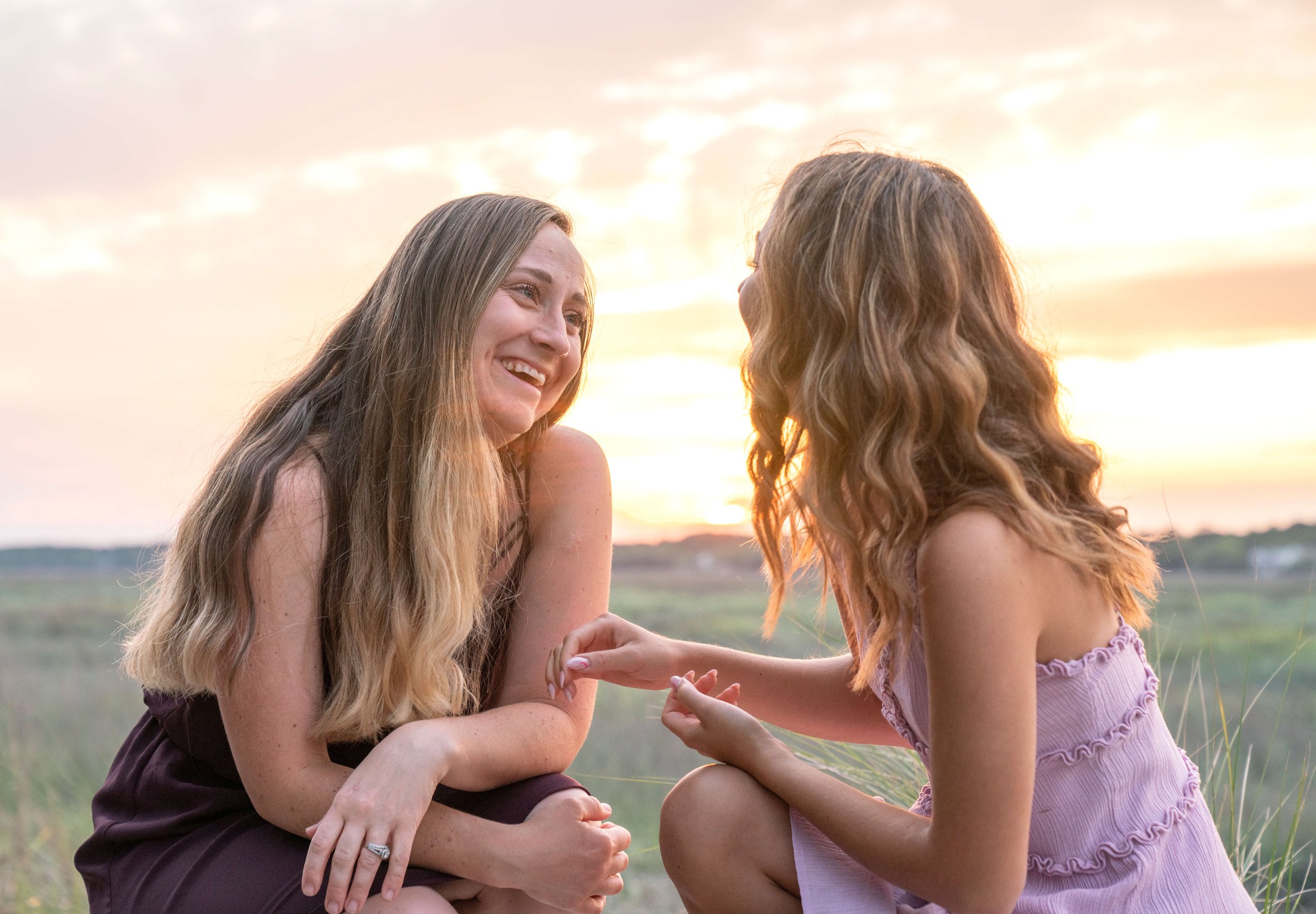 Mother and daughter looking at each other with the sun setting in the background