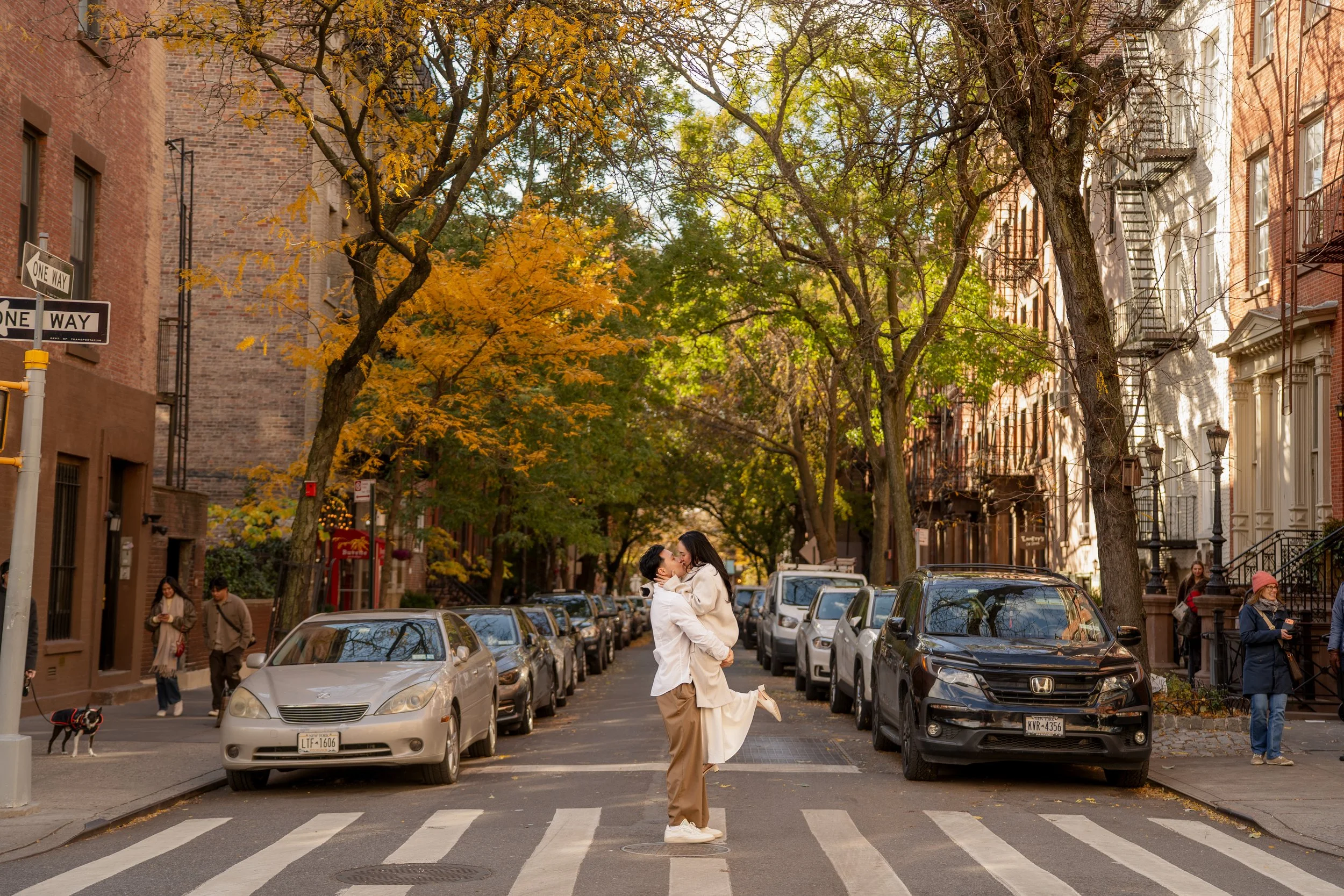Engagement photos of a couple in the streets of West Village in NYC. The couple is kissing in the middle of a crosswalk.