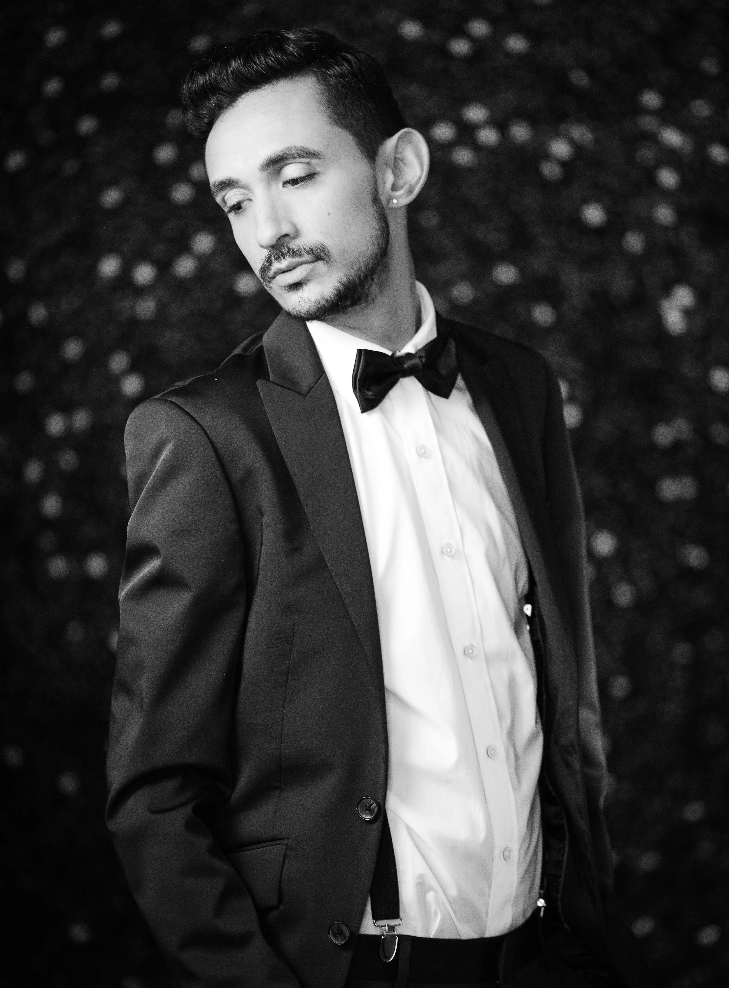 Hombre joven con esmoquin y pajarita en blanco y negro.