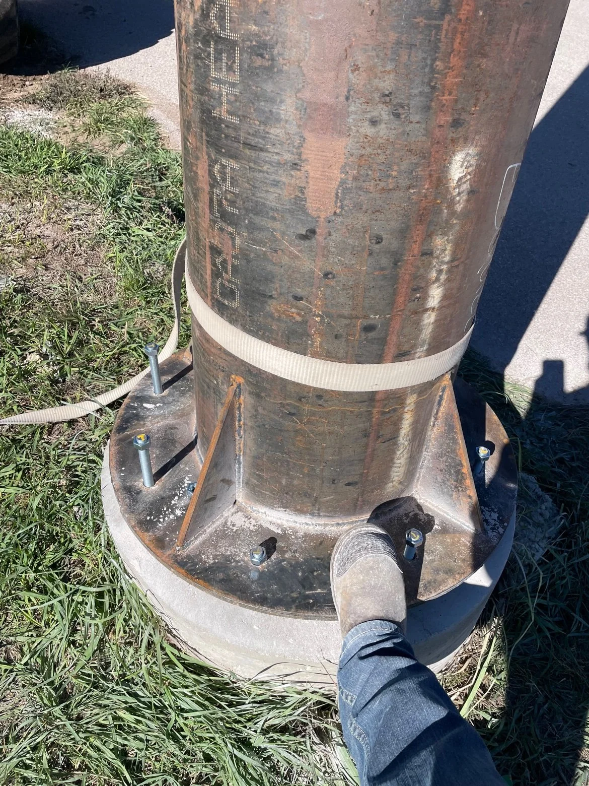Entrance post base plate with gussets and anchor bolts on a concrete pier