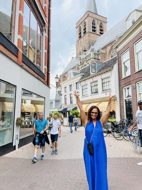 Monique Mannen exploring a historic European city, embracing a lifestyle of vitality, wellness, and joyful aging.